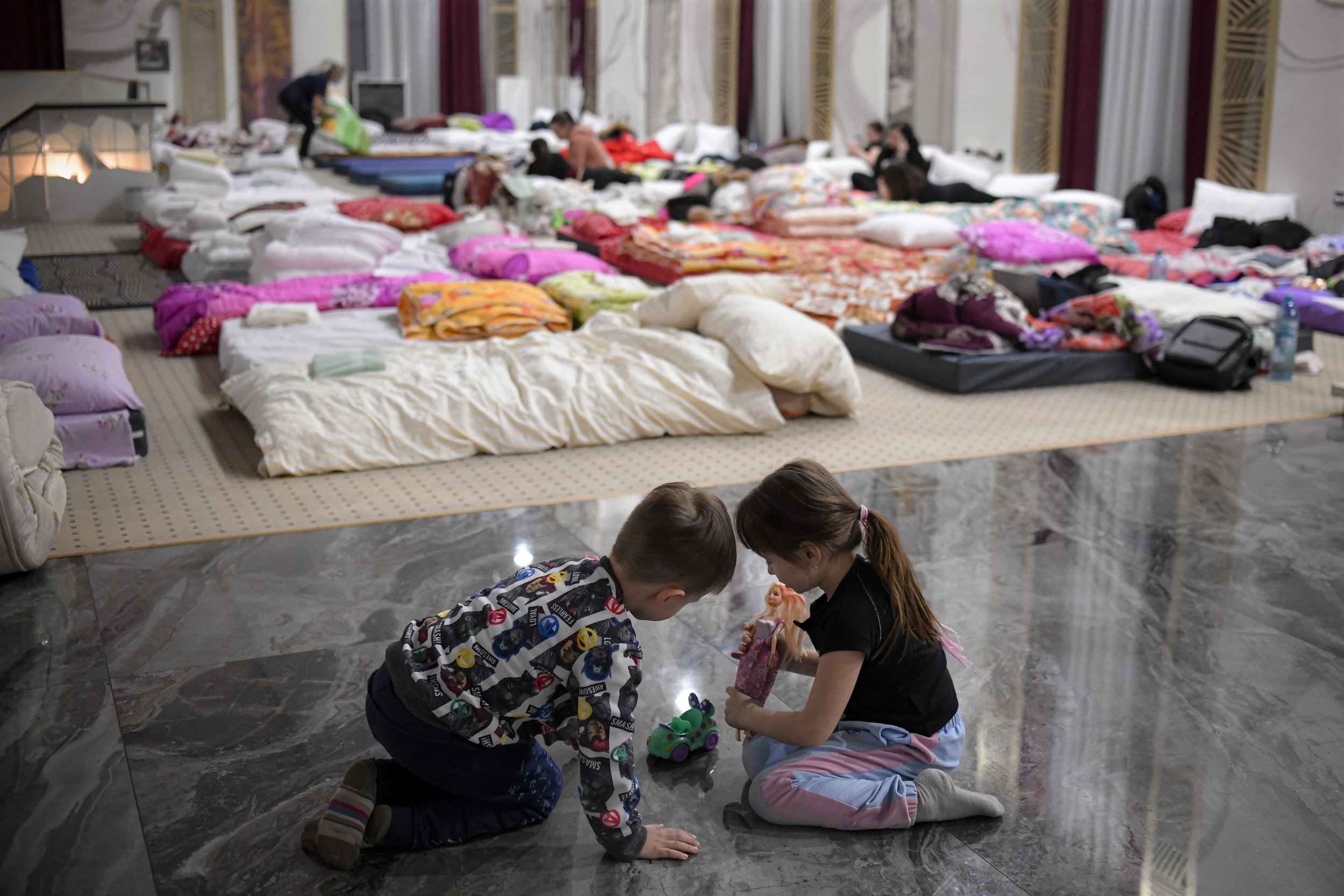  Children who fled the conflict from neighboring Ukraine play on the floor of an event hall in a hotel offering shelter in Siret, Romania, Saturday, Feb. 26, 2022. (AP Photo/Andreea Alexandru) 