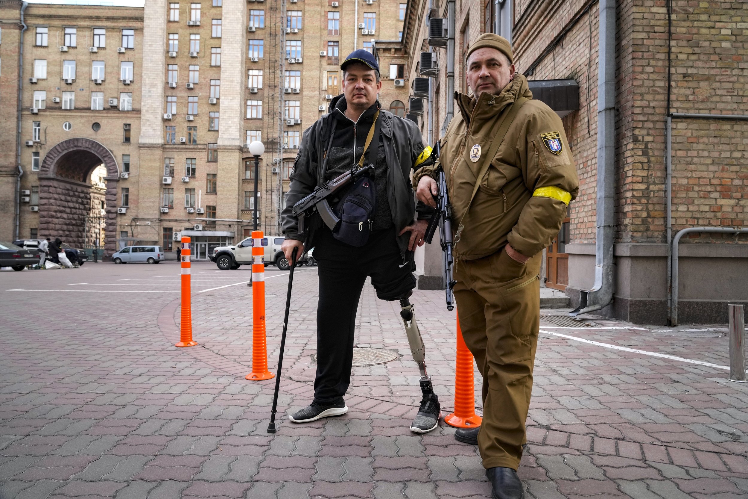  Armed civil defense men pose for a photo while patrolling an empty street due to curfew in Kyiv, Ukraine, Sunday, Feb. 27, 2022. (AP Photo/Efrem Lukatsky) 