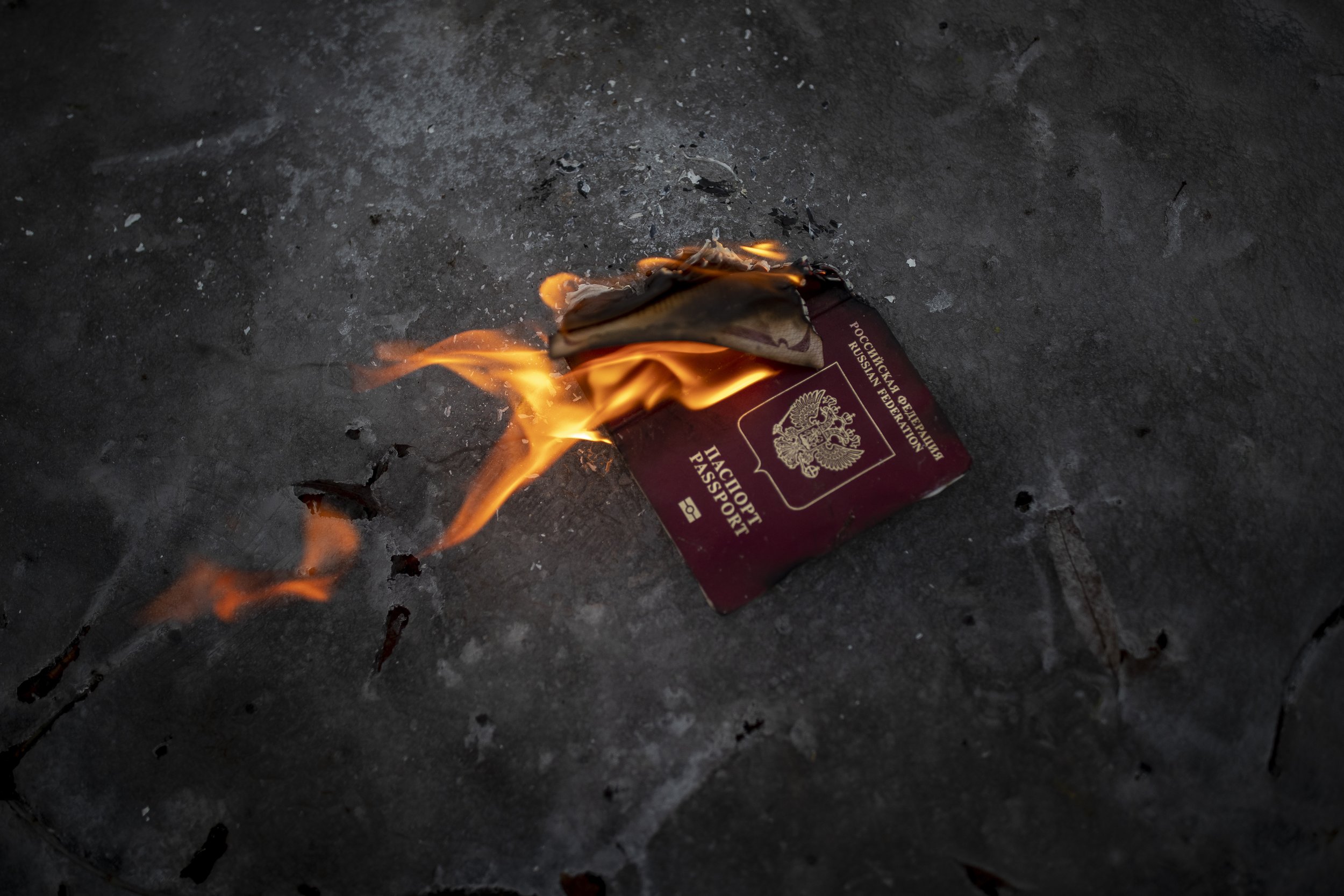  Protesters burn a Russian passport to demonstrates against Russian attacks in Ukraine in front of the Russian embassy in Vilnius, Lithuania, Thursday, Feb. 24, 2022. (AP Photo/Mindaugas Kulbis) 
