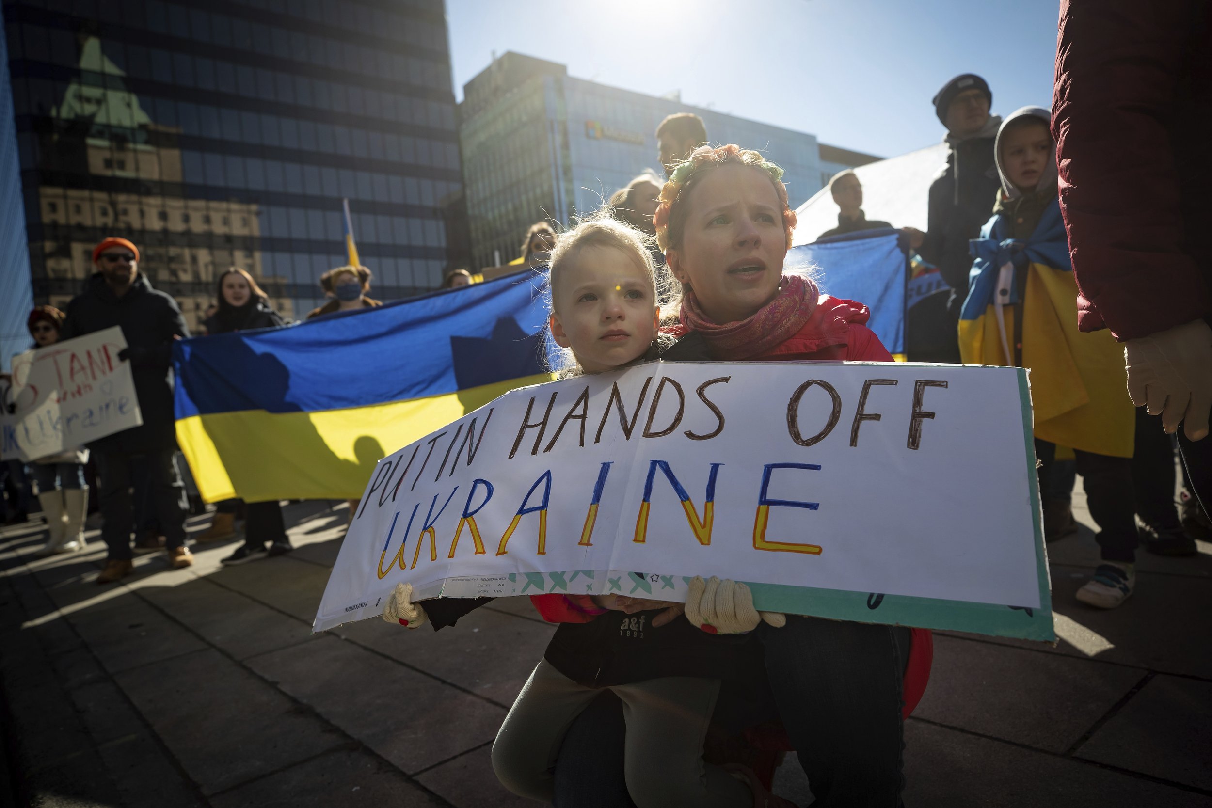  A woman and a young child hold a sign during a rally in support of the people of Ukraine, Thursday, Feb. 24, 2022, in Vancouver, British Columbia. (Darryl Dyck/The Canadian Press via AP) 
