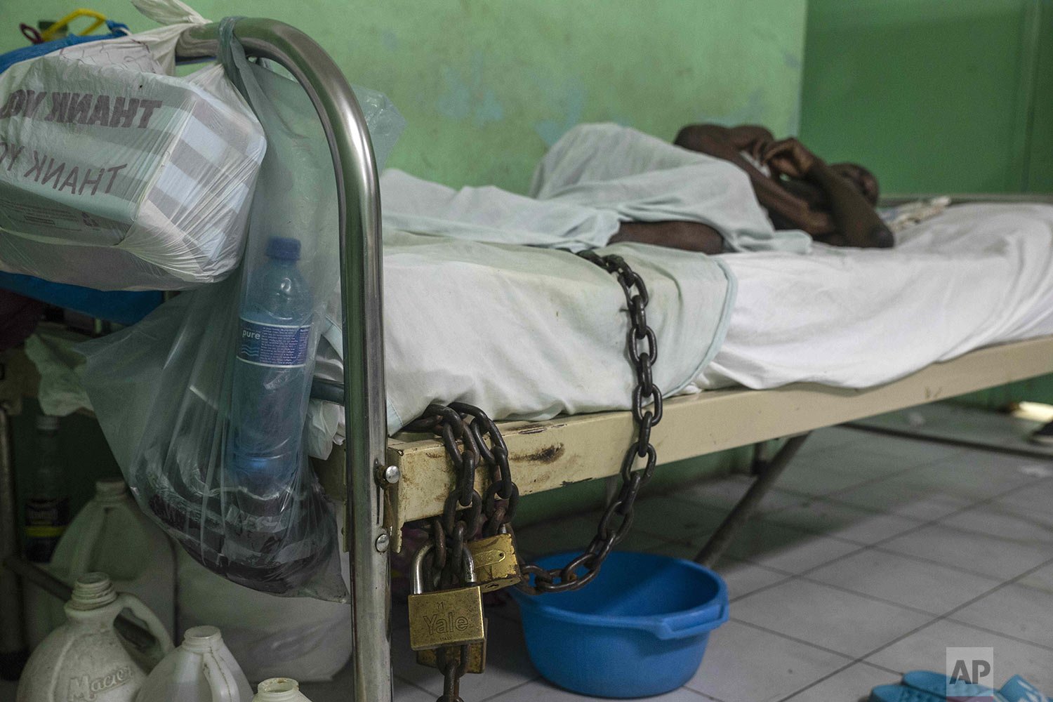  A chained prisoner lies on a bed at the General Hospital during a strike by hospital workers demanding better working conditions in Port-au-Prince, Haiti, Feb. 25, 2022. (AP Photo/Odelyn Joseph) 
