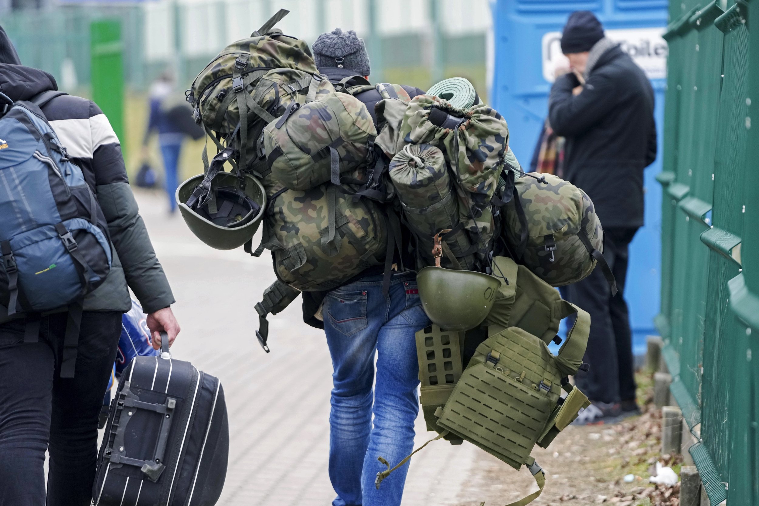 A man carries combat gear as he leaves Poland to fight in Ukraine, at the border crossing in Medyka, Poland, Wednesday, March 2, 2022. (AP Photo/Markus Schreiber)