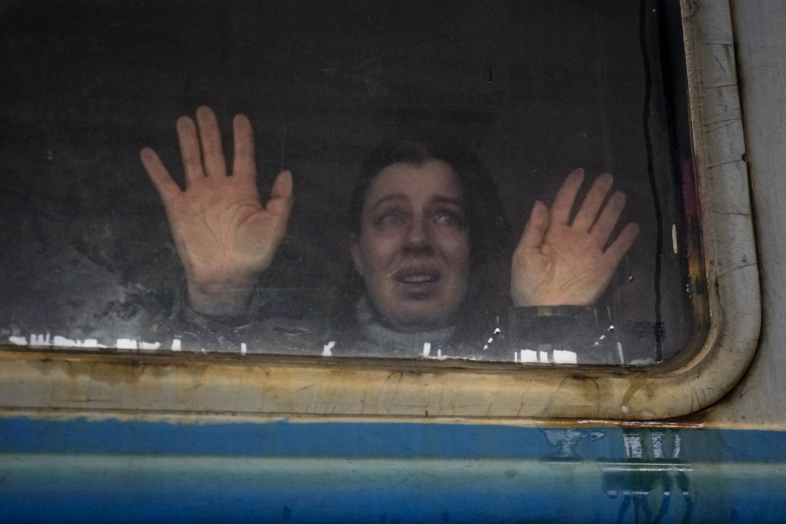  A woman looks toward relatives and presses her palms against a window of a Lviv bound train, on the platform in Kyiv, Ukraine, Thursday, March 3, 2022. (AP Photo/Vadim Ghirda) 
