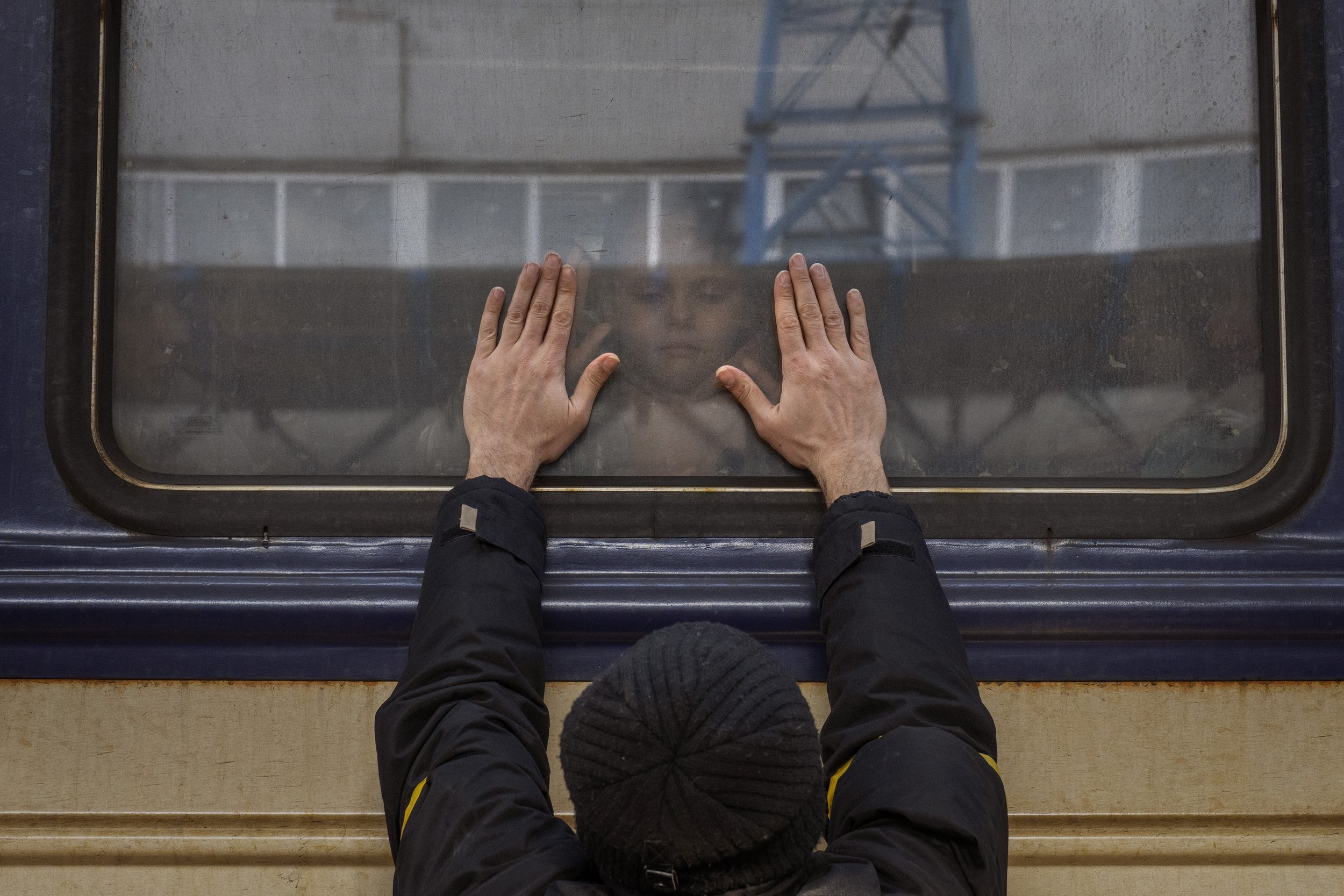 Aleksander, 41, presses his palms against the window as he says goodbye to his daughter Anna, 5, on a train to Lviv at the Kyiv station, Ukraine, Friday, March 4. 2022. Aleksander has to stay behind to fight in the war while his family leaves the co