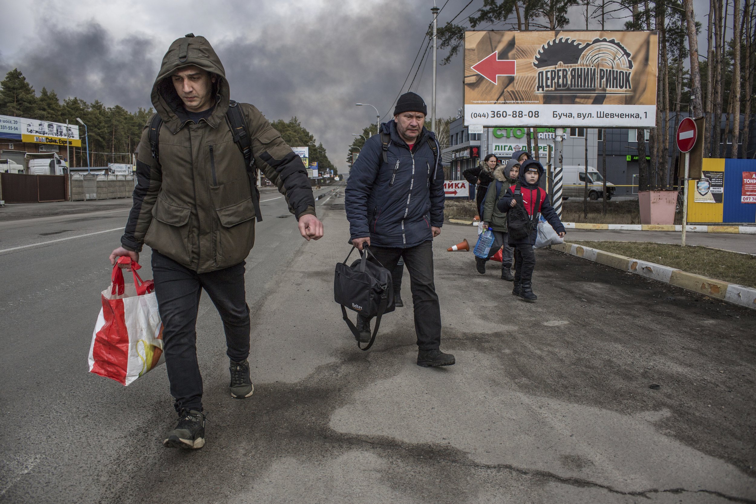 People leave the town of Bucha, close to Kyiv, Ukraine, Friday, March 4, 2022. (AP Photo/Oleksandr Ratushniak)