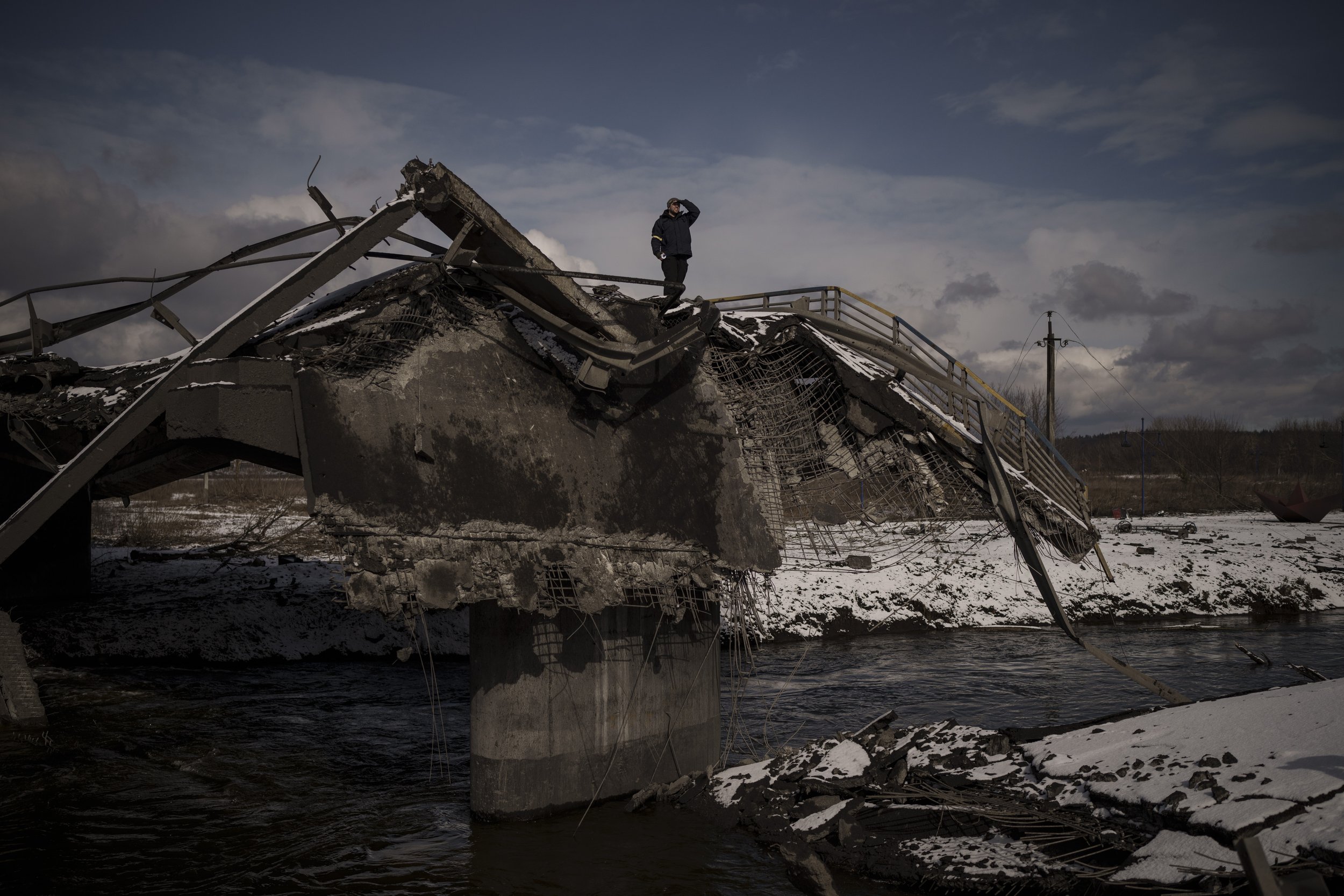  A man stands atop a destroyed bridge in Irpin, on the outskirts of Kyiv, Ukraine, Tuesday, March 8, 2022. (AP Photo/Felipe Dana) 