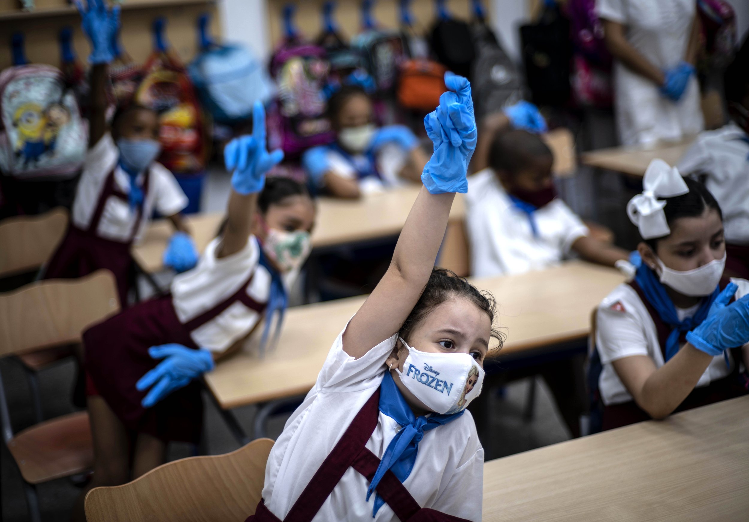  Wearing masks and plastic gloves amid the spread of the new coronavirus, girls raise her hands during class in Havana, Cuba, Monday, Nov. 2, 2020. (AP Photo/Ramon Espinosa) 