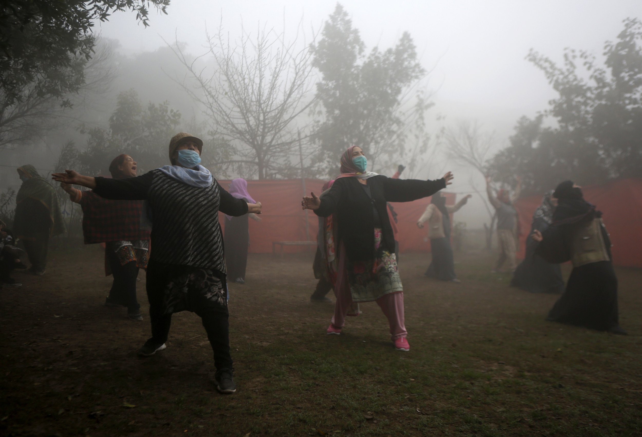  Woman attend their yoga exercise in a park while heavy fog envelops the areas of Lahore, Pakistan, Wednesday, Feb. 17, 2021. (AP Photo/K.M. Chaudary) 