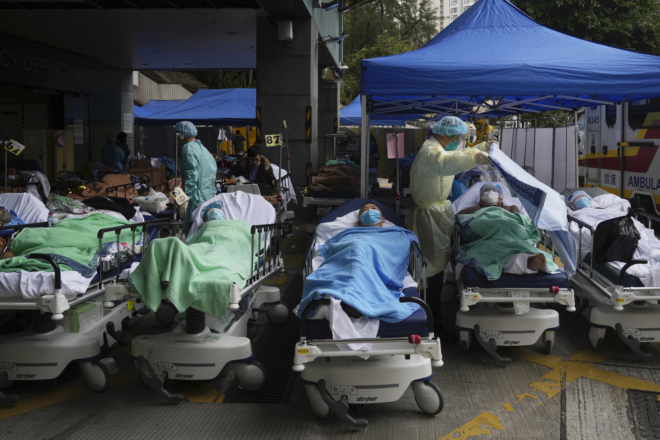  Patients lie on hospital beds as they wait at a temporary makeshift treatment area outside Caritas Medical Centre in Hong Kong, Friday, Feb. 18, 2022. Hong Kong's hospitals reached 90% capacity on Thursday and quarantine facilities were at their lim