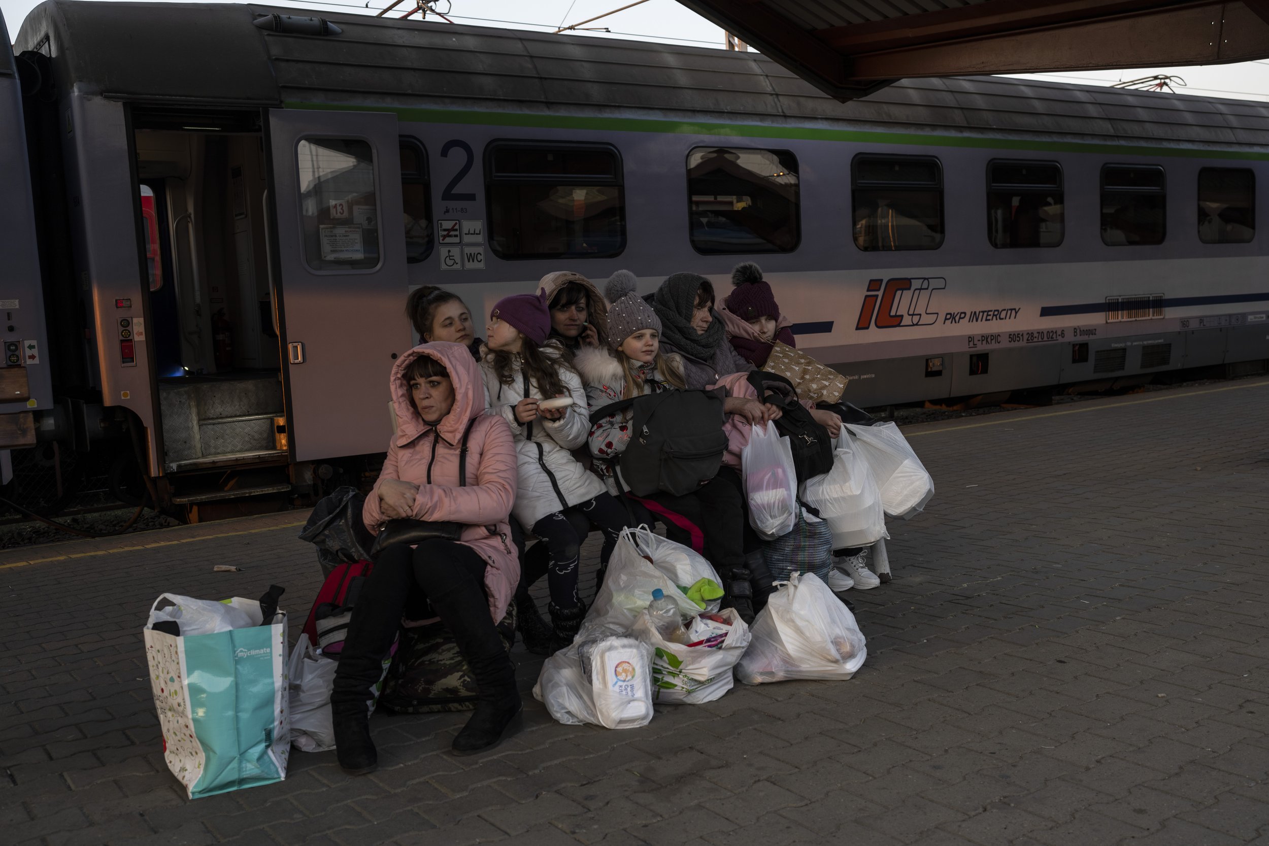  A Ukrainian family who fled the war wait at the train station in Przemysl, southeastern Poland, on Sunday, March 13, 2022. Now in its third week, the war has forced more than 2.5 million people to flee Ukraine. (AP Photo/Petros Giannakouris) 