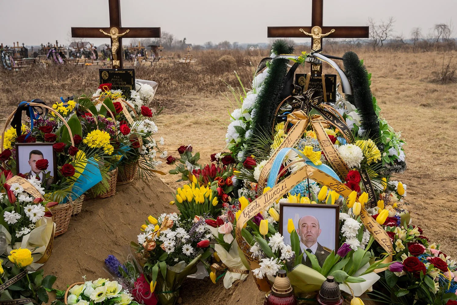  Flowers are placed around the graves of Ukrainian military servicemen Roman Rak and Mykola Mykytiuk in Starychi, western Ukraine, Wednesday, March 16, 2022. Rak and Mykytiu were killed during Sunday's Russian missile strike on a military training ba