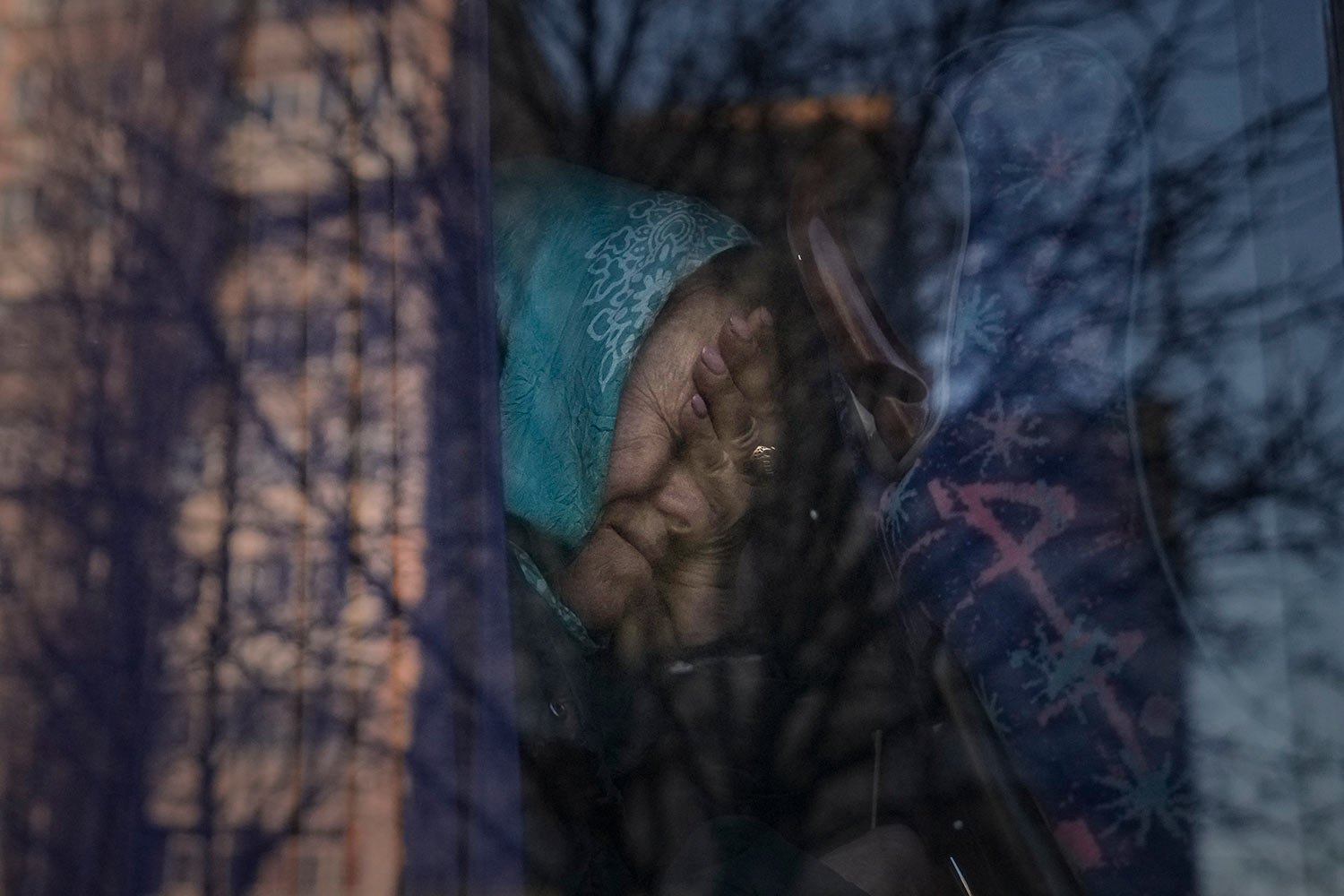  A refugee cries on a bus while waiting for Ukrainian police to check papers and belongings in Brovary, Ukraine, Sunday, March 20, 2022, after being evacuated from the village of Bobrik, reportedly under Russian military control. (AP Photo/Vadim Ghir