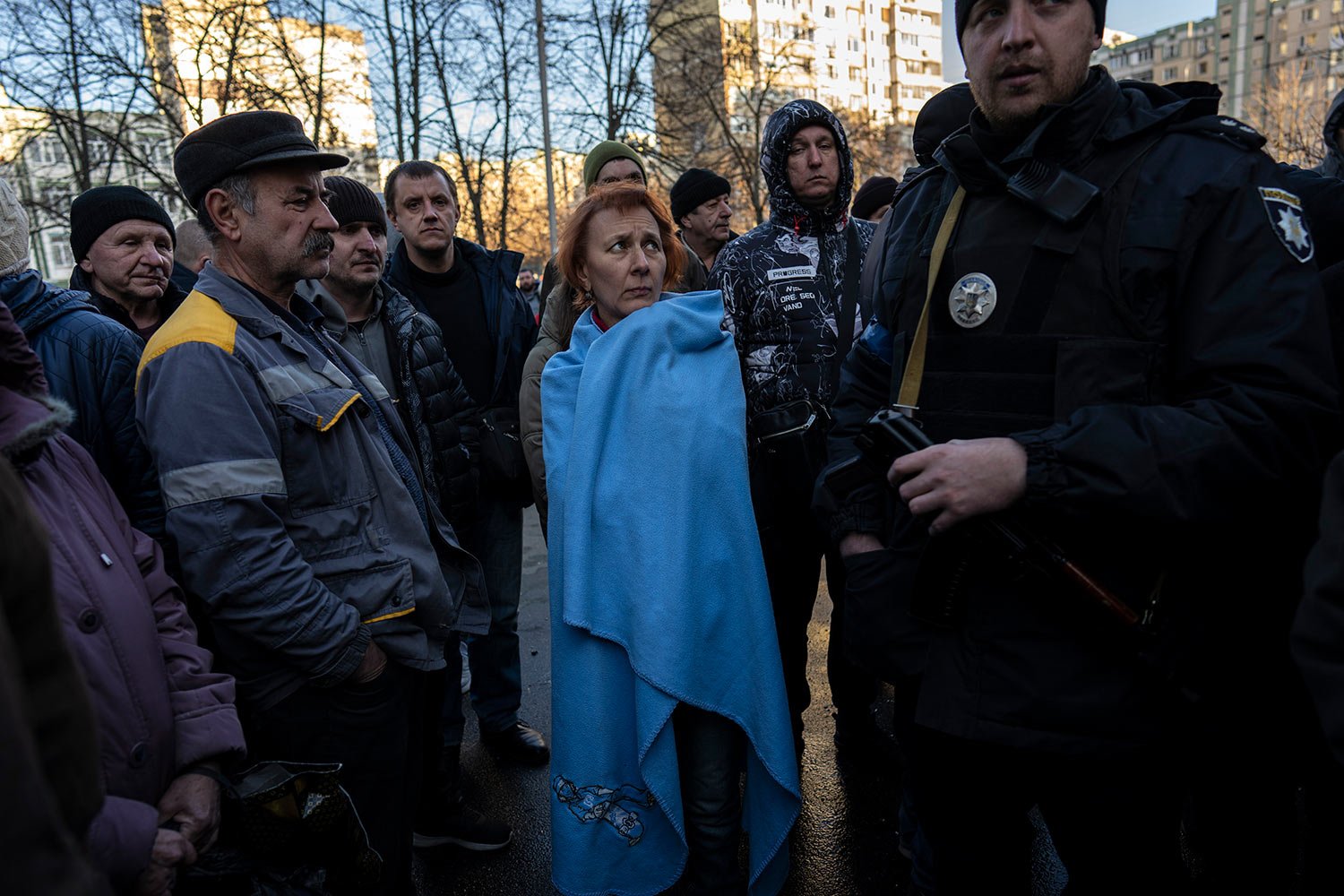  Natacha, center, listens to a policeman while waiting with other neighbors to be cleared to enter their apartments damaged by a bomb in Satoya neighborhood in Kyiv, Ukraine, Sunday, March 20, 2022. (AP Photo/Rodrigo Abd) 