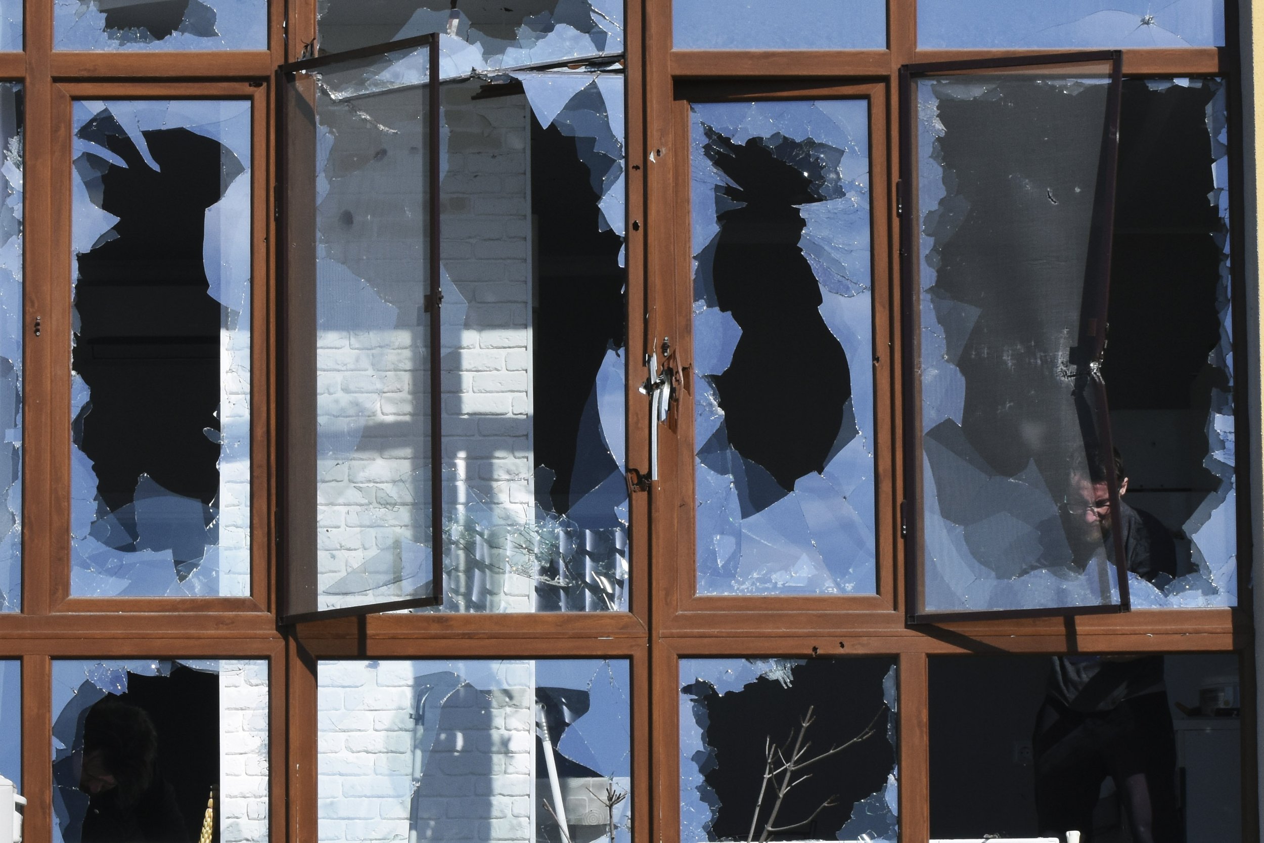  A man appears through shattered windows of a building after a shelling in Odesa, Ukraine, Monday, March 21, 2022. (AP Photo/Max Pshybyshevsky) 