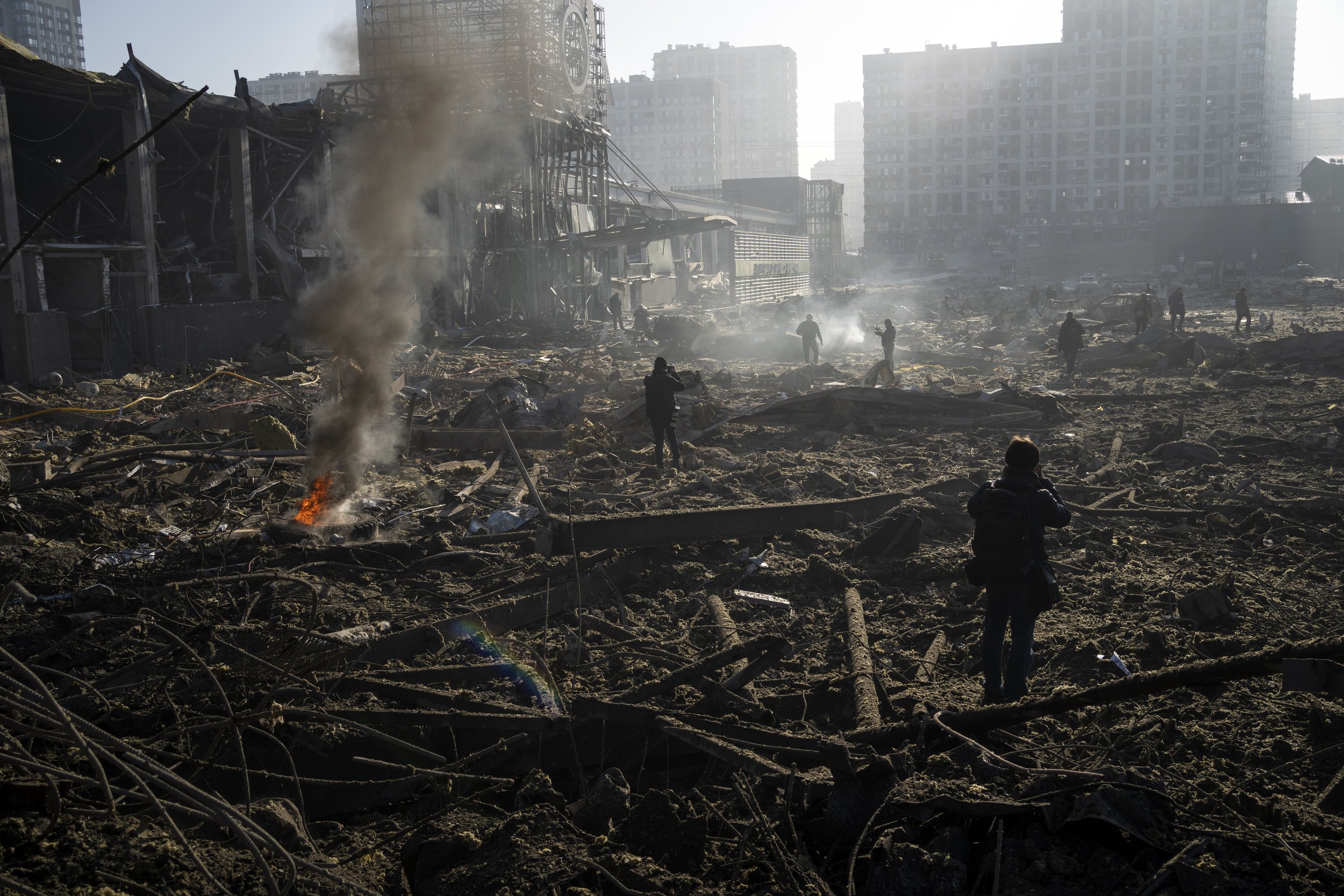  People gather amid the destruction caused after shelling of a shopping center, in Kyiv, Ukraine, Monday, March 21, 2022. (AP Photo/ (AP Photo/Rodrigo Abd) 