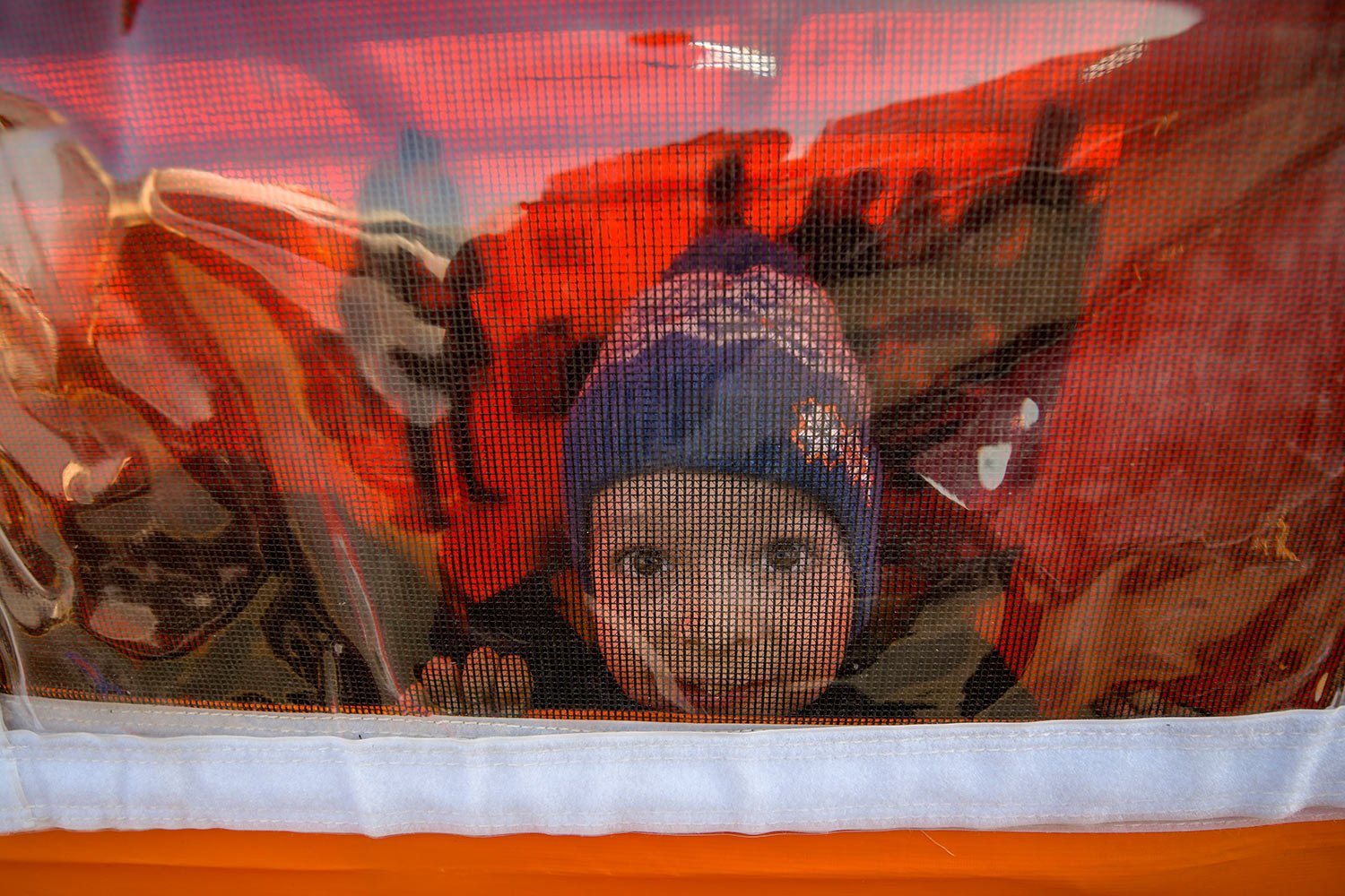  A refugee fleeing the war from neighbouring Ukraine with his family looks out of a tent after crossing the border by ferry at the Isaccea-Orlivka border crossing in Romania, Thursday, March 24, 2022. (AP Photo/Andreea Alexandru) 