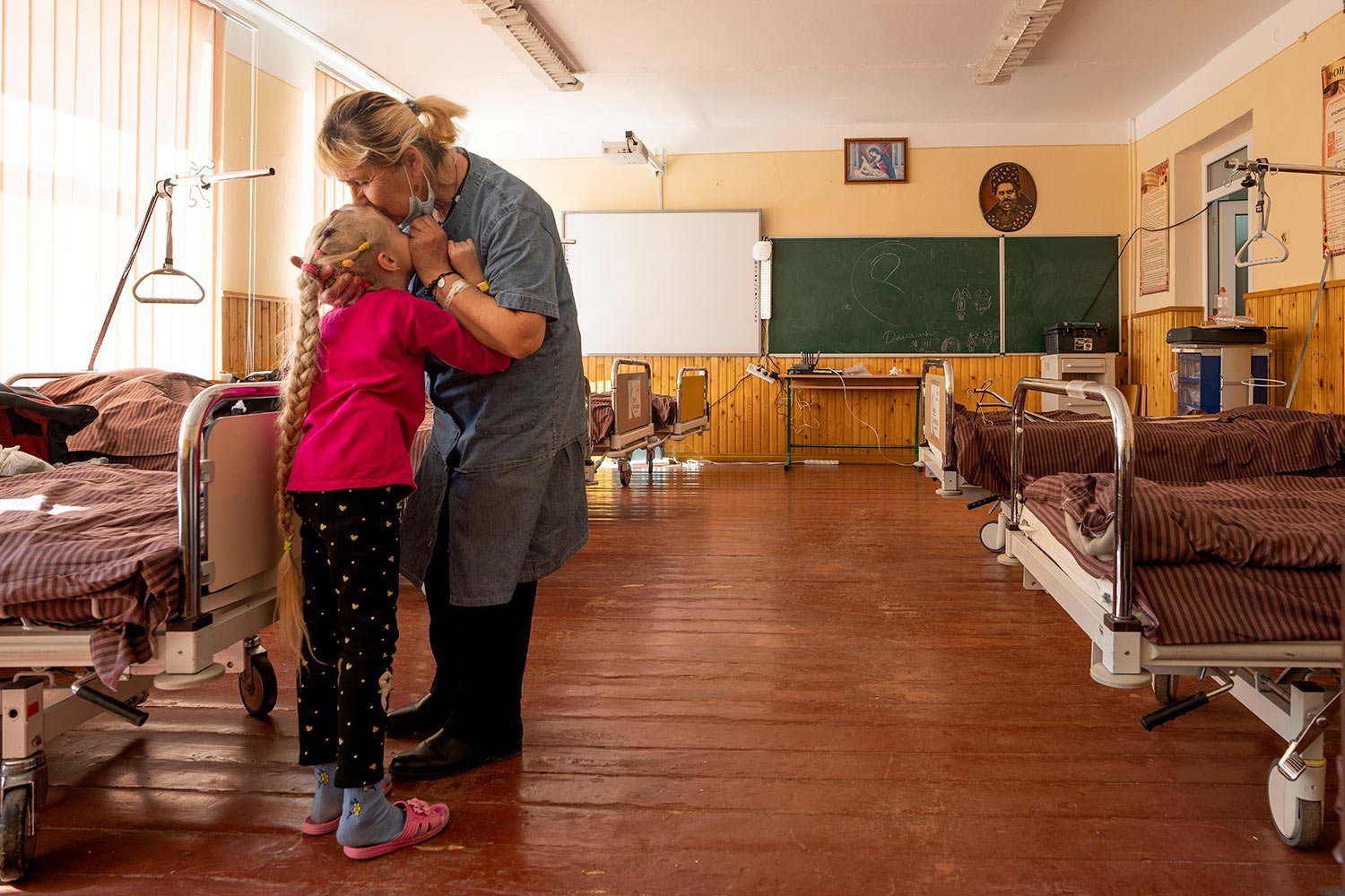  Nadia kisses her 10-year-old granddaughter Zlata Moiseinko, suffering from a chronic heart condition, as she receives treatment at a schoolhouse that has been converted into a field hospital in Mostyska, western Ukraine, Thursday, March 24, 2022. (A