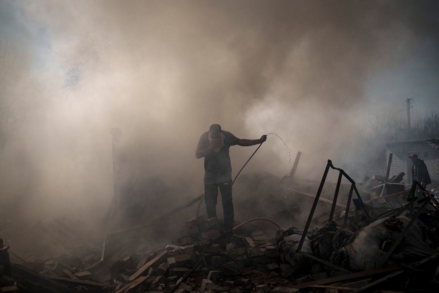  Neighbours try to extinguish the fire of a house, destroyed after a Russian attack in Kharkiv, Ukraine, Thursday, March 24, 2022. (AP Photo/Felipe Dana) 