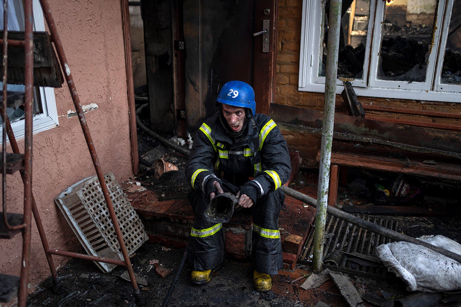  A Ukrainian firefighter takes a break from extinguishing a fire inside a house destroyed by shelling in Kyiv, Ukraine, Wednesday, March 23, 2022. (AP Photo/Rodrigo Abd) 