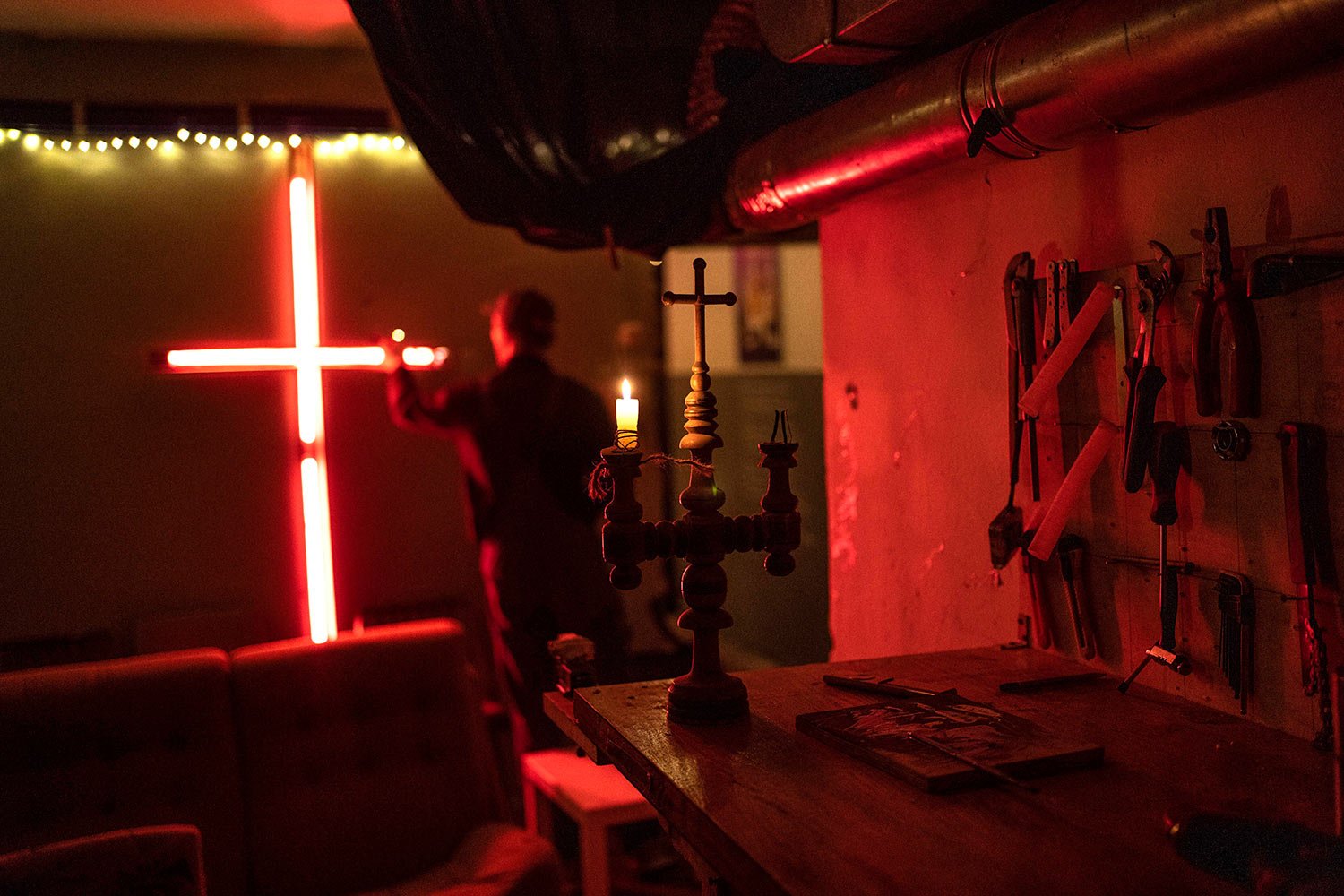  A man lights a candle in an artist's co-living studio space that is used as a bomb shelter and a place to help the Territorial Defense Units, in Kyiv, Ukraine, Wednesday, March 23, 2022. (AP Photo/Rodrigo Abd) 