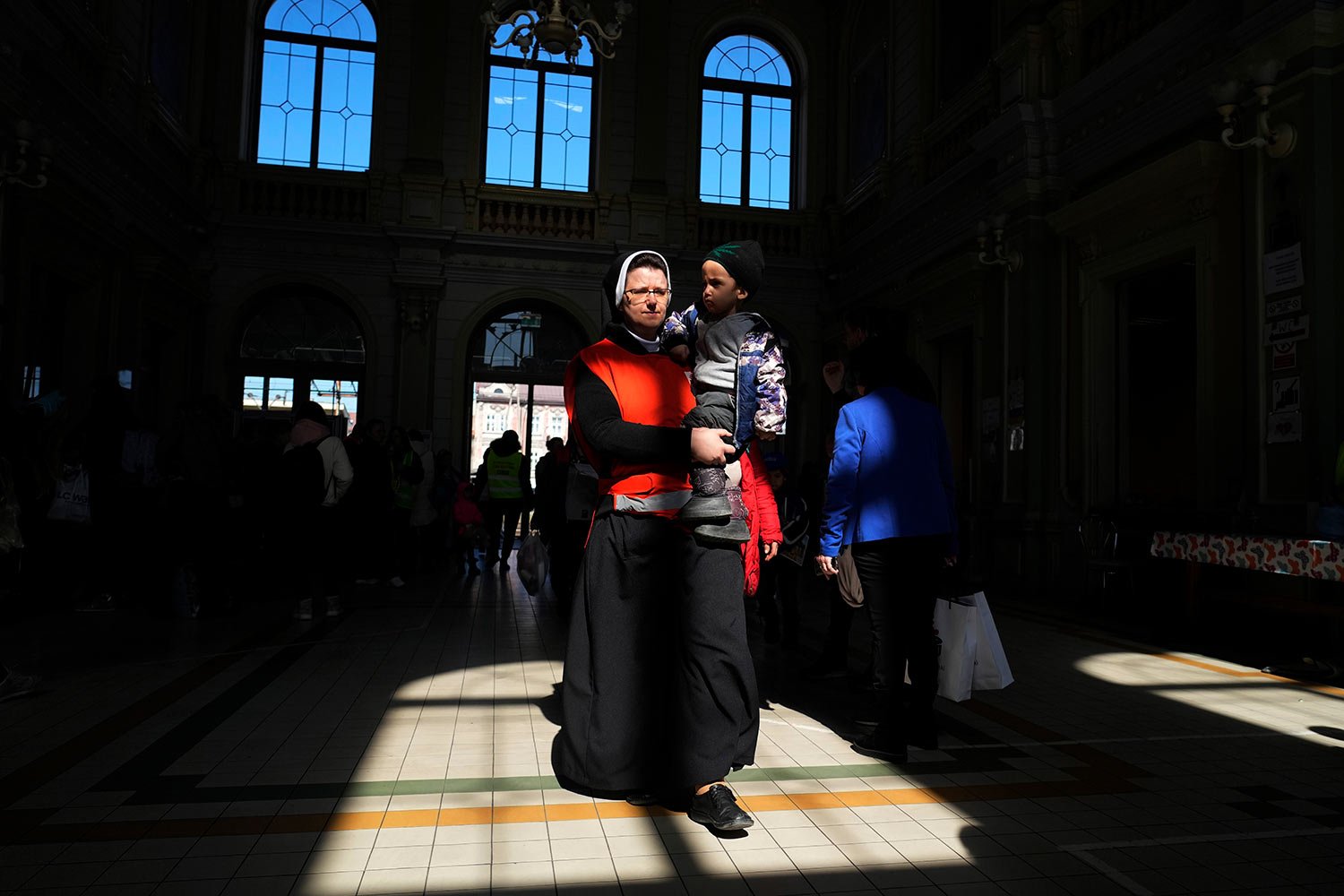  A Catholic nun helping as a volunteer, carries a boy from Ukraine at a railway station in Przemysl, southeastern Poland, on Wednesday, March 23, 2022. (AP Photo/Sergei Grits) 