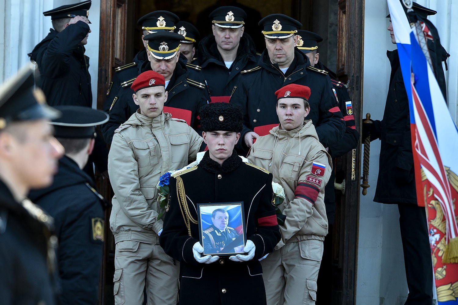  A serviceman carries the photo of Capt. Andrei Paliy, a deputy commander of Russia's Black Sea Fleet, during a farewell ceremony in Sevastopol, Crimea, Wednesday, March 23, 2022. Paliy was killed in action during fighting with Ukrainian forces in th