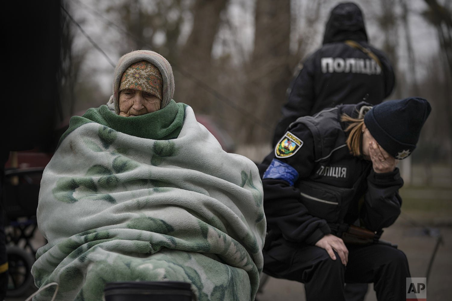  A Ukrainian police officer is overwhelmed by emotion after comforting people evacuated from Irpin on the outskirts of Kyiv, Ukraine, Saturday, March 26, 2022. Russia continues to pound cities throughout Ukraine — explosions rang out Saturday near th