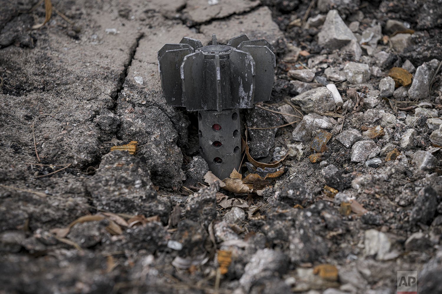 A part of a mortar shell sticks out of the asphalt in Stoyanka, Ukraine, Sunday, March 27, 2022. (AP Photo/Vadim Ghirda) 