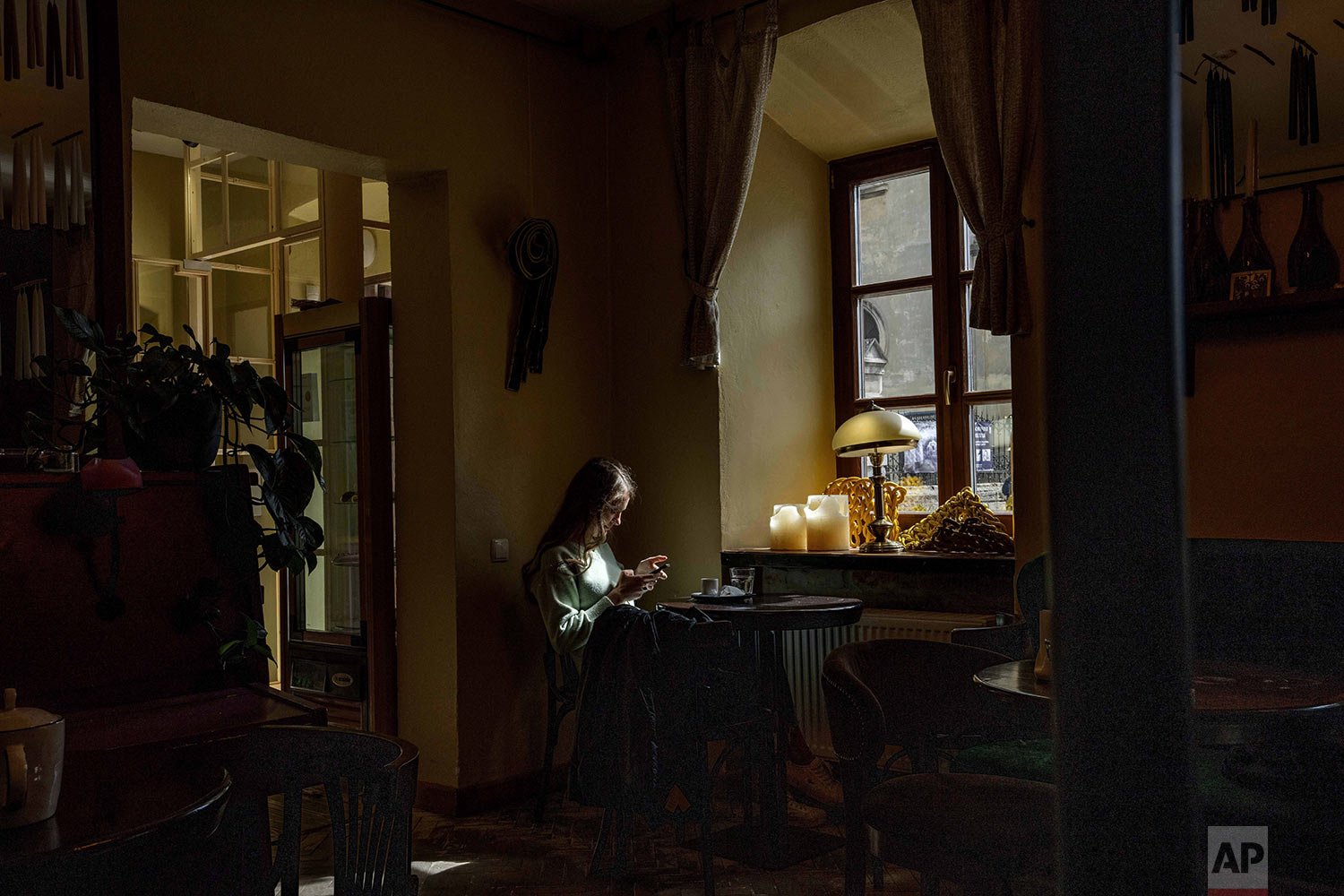  A woman sits inside a coffee shop in Lviv, western Ukraine, Sunday, March 27, 2022. (AP Photo/Nariman El-Mofty) 