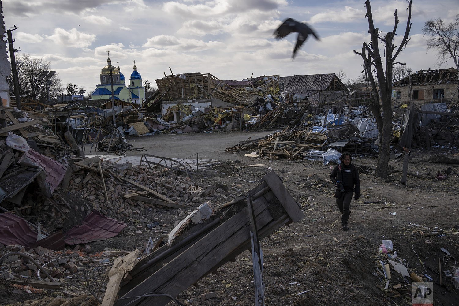  A journalist walks amid the destruction after a Russian attack in Byshiv on the outskirts of Kyiv, Ukraine, Sunday, March 27, 2022. (AP Photo/Rodrigo Abd) 