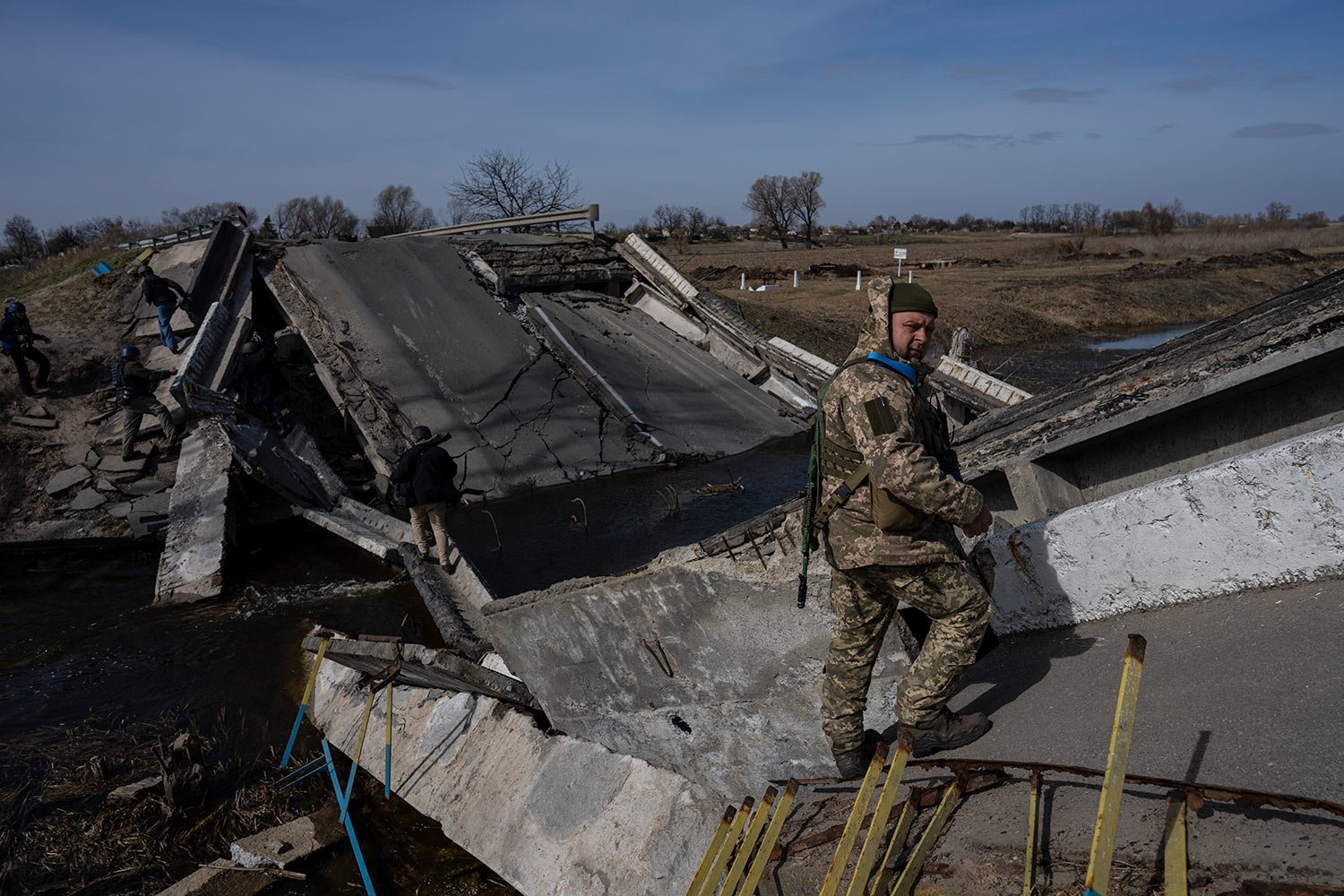  A soldier stands on a bridge destroyed by the Ukrainian army to prevent the passage of Russian tanks near Brovary, in the outskirts of Kyiv, Ukraine, Monday, March 28, 2022. (AP Photo/Rodrigo Abd) 