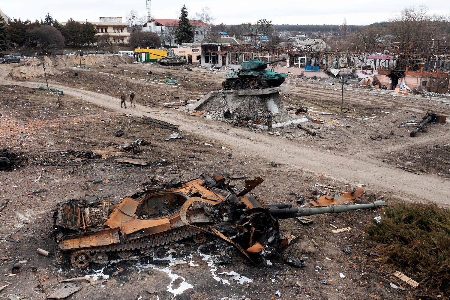  Local residents pass by a damaged Russian tank in the town of Trostyanets, east of capital Kyiv, Ukraine, Monday, March 28, 2022. The monument to Second World War is seen in background. (AP Photo/Efrem Lukatsky) 