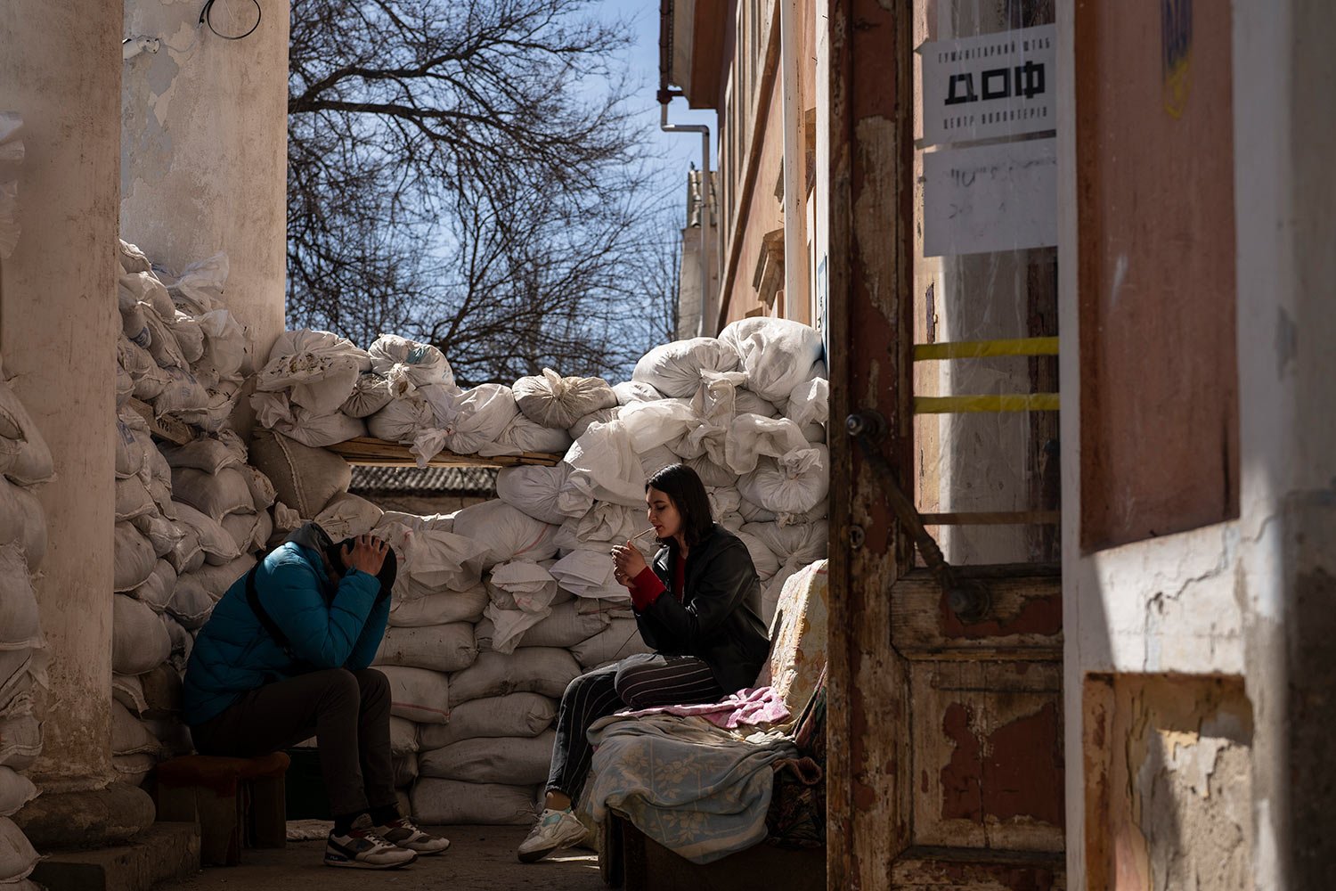  A volunteer smokes next to sandbags used for protection, at a Ukrainian volunteer center in Mykolaiv, southern Ukraine, on Monday, March 28, 2022. (AP Photo/Petros Giannakouris) 