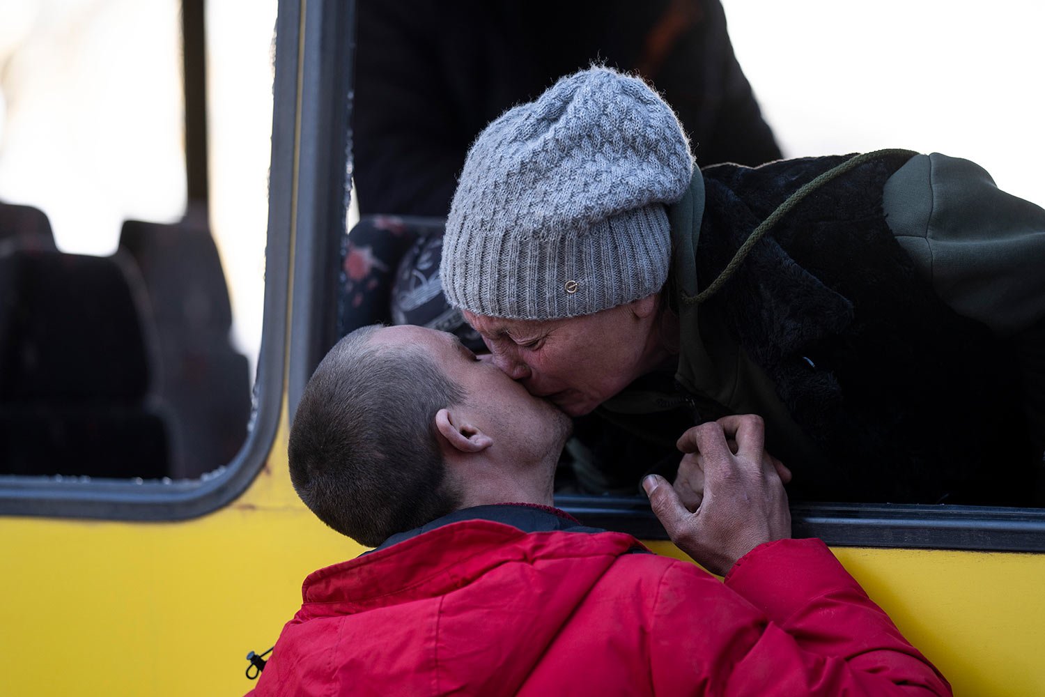  Mykolaivna Shankarukina, 54, kisses her son from inside a damaged bus as she is leaving from the Ukrainian Red Cross center in Mykolaiv, southern Ukraine, on Monday, March 28, 2022. Shankarukina and her family evacuated from Sablagodante village in 