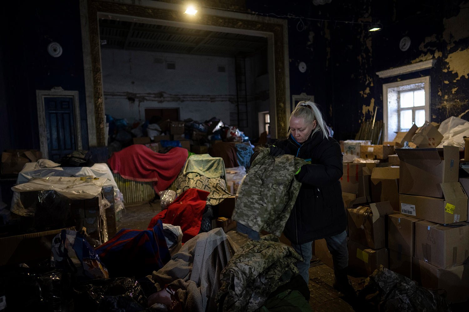  A volunteer folds army clothes inside a Ukrainian volunteer center in Mykolaiv, southern Ukraine, on Monday, March 28, 2022. Ukrainian volunteers have set up a center to supply army and civilians with clothes, food, medicines and makeshift bullet pr