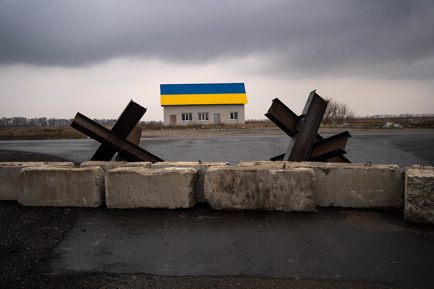  Anti-tank barriers are displayed near a house painted with the colors of the Ukraine flag near Malaya Alexandrovka village, on the outskirts of Kyiv, Ukraine, Wednesday, March 30, 2022. (AP Photo/Rodrigo Abd) 