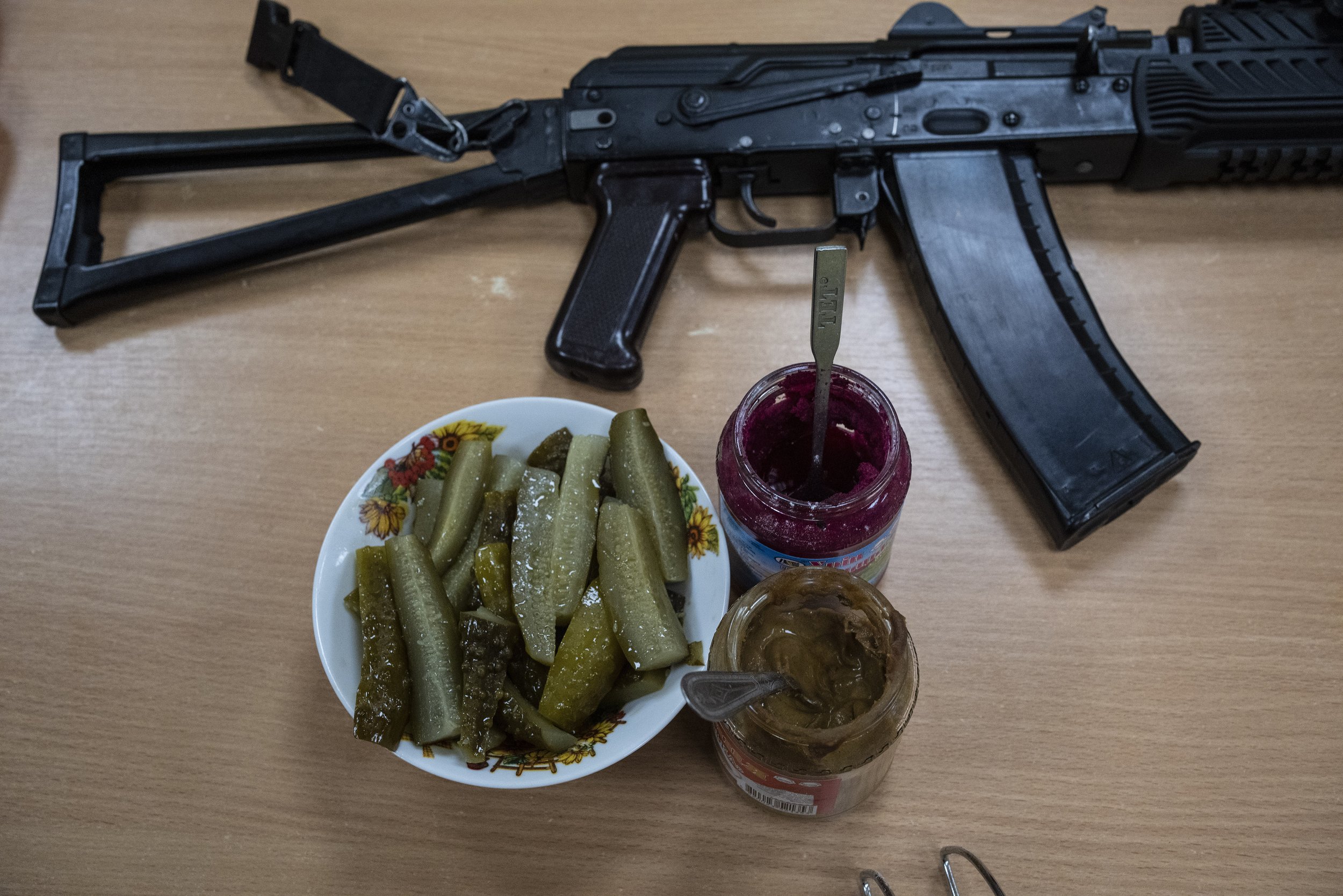  A machine gun of a Ukrainian soldier rests next to condiments for lunch in the outskirts of Kyiv, Ukraine, Thursday, March 31, 2022. (AP Photo/Rodrigo Abd) 