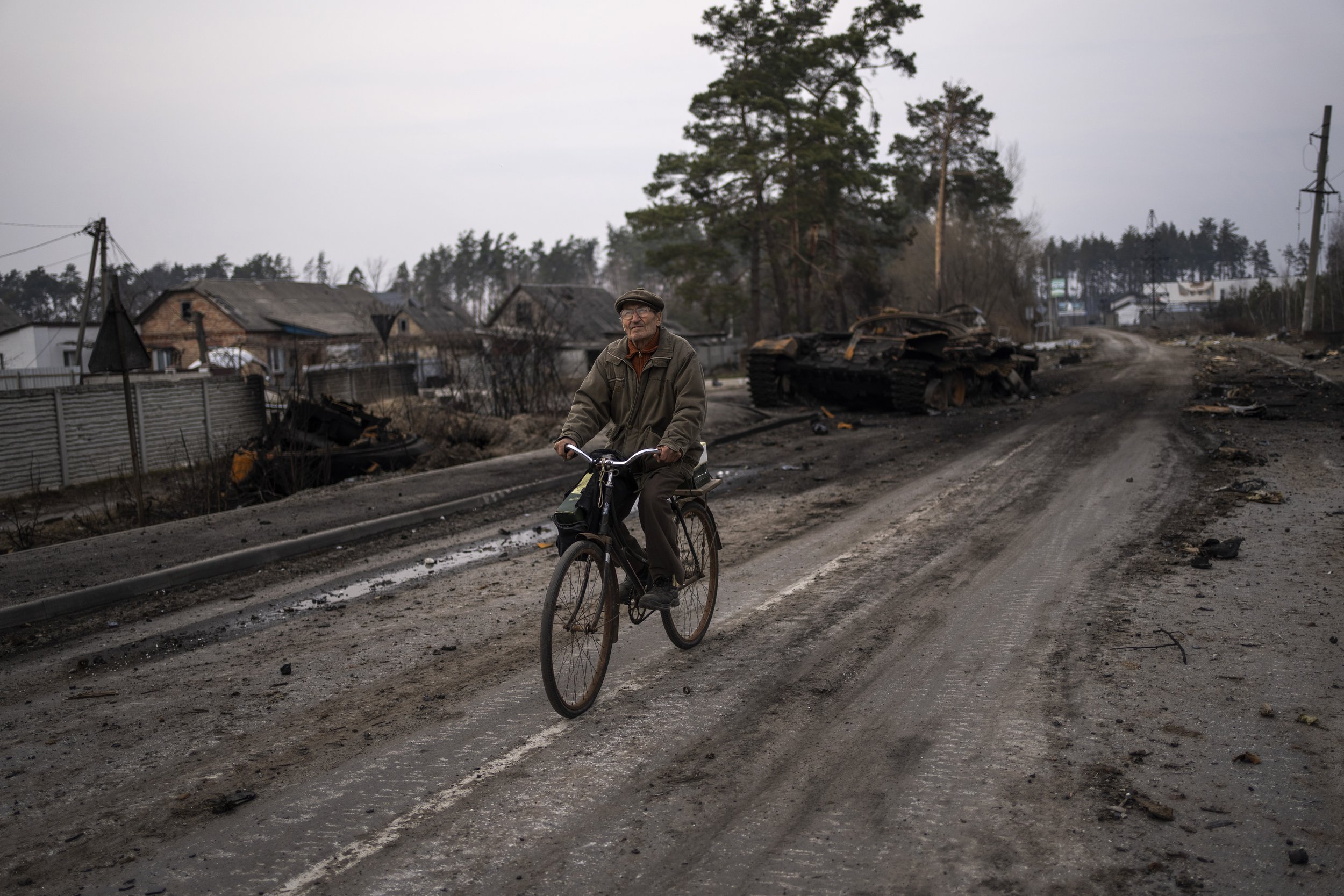  Oleksandr, 81, rides a bicycle next to a destroyed Russian tank in the outskirts of Kyiv, Ukraine, Thursday, March 31, 2022. (AP Photo/Rodrigo Abd) 