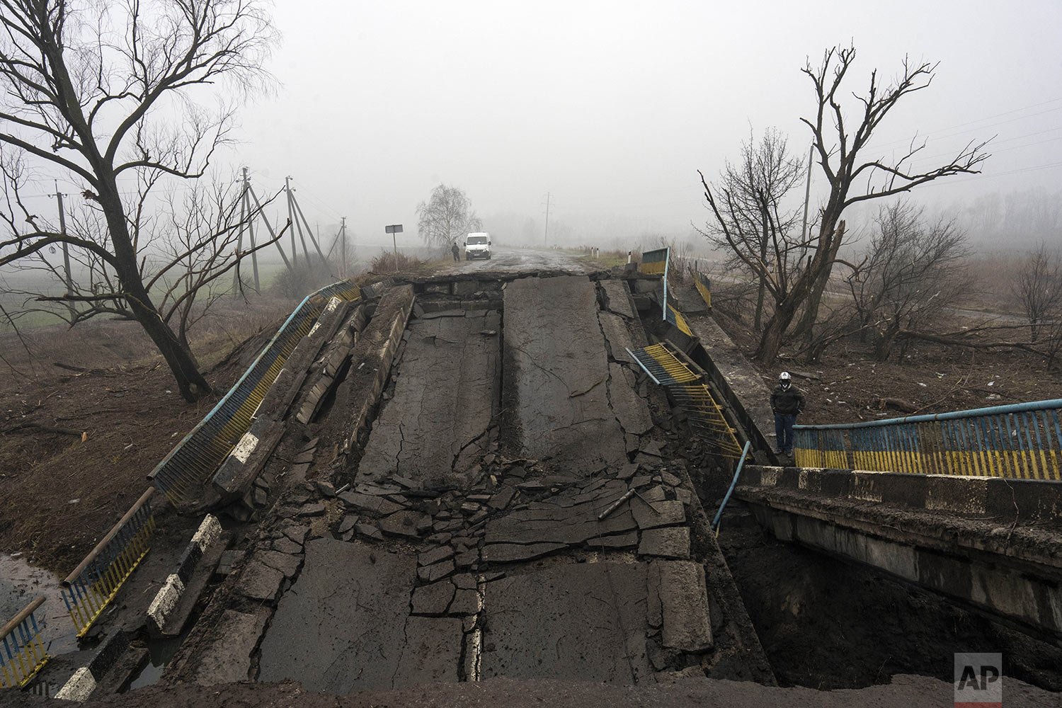  A man stands alongside a bridge destroyed by Russian soldiers upon their retreat from villages on the outskirts of Kyiv, Ukraine, Friday, April 1, 2022. (AP Photo/Rodrigo Abd) 