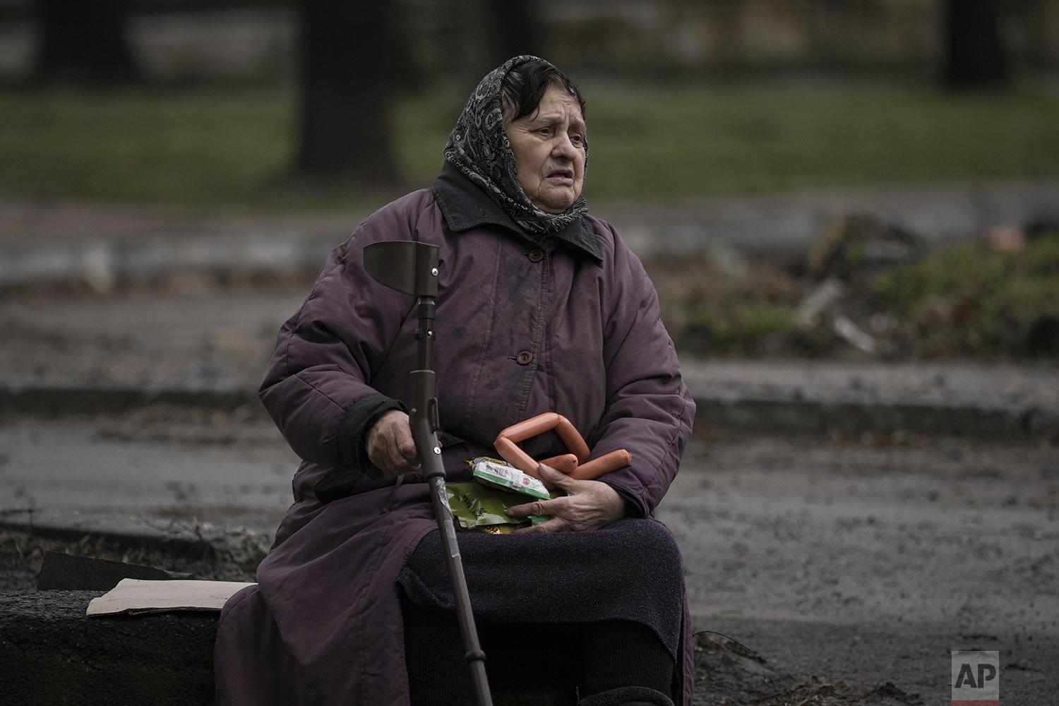  A woman holds food items she received after a convoy of military and aid vehicles arrived in the formerly Russian-occupied Kyiv suburb of Bucha, Ukraine, Saturday, April 2, 2022. (AP Photo/Vadim Ghirda) 