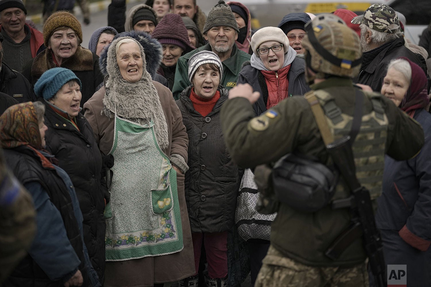  Civilians cheer along with a Ukrainian serviceman as a convoy of military and aid vehicles arrives in the formerly Russian-occupied Kyiv suburb of Bucha, Ukraine, Saturday, April 2, 2022.  (AP Photo/Vadim Ghirda) 