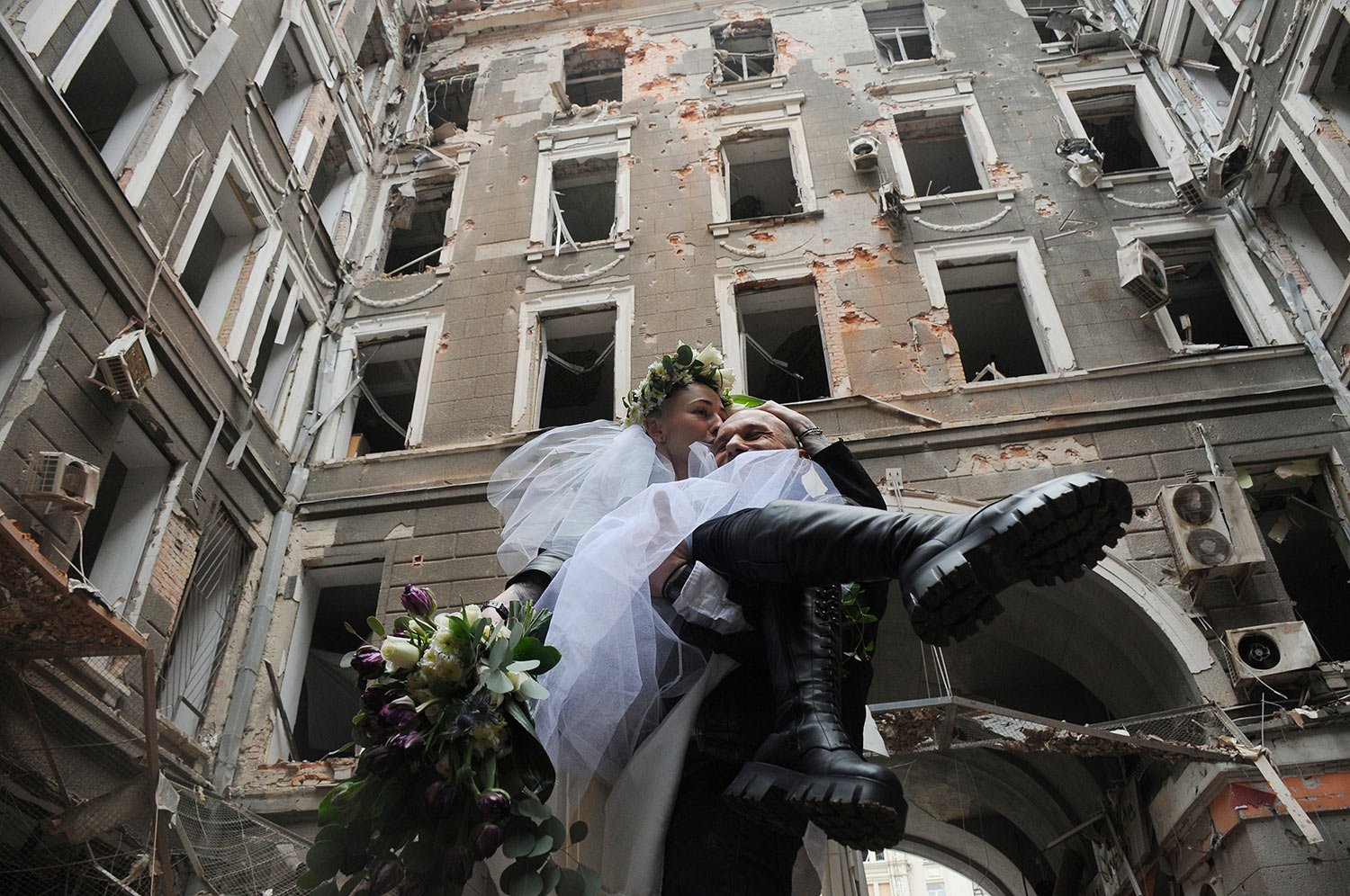  Volunteers Anastasia, left, and Anton pose for a picture in a yard of an apartment building destroyed by shelling during their wedding celebration in Kharkiv, Ukraine, Sunday, April 3, 2022. (AP Photo/Andrew Marienko) 