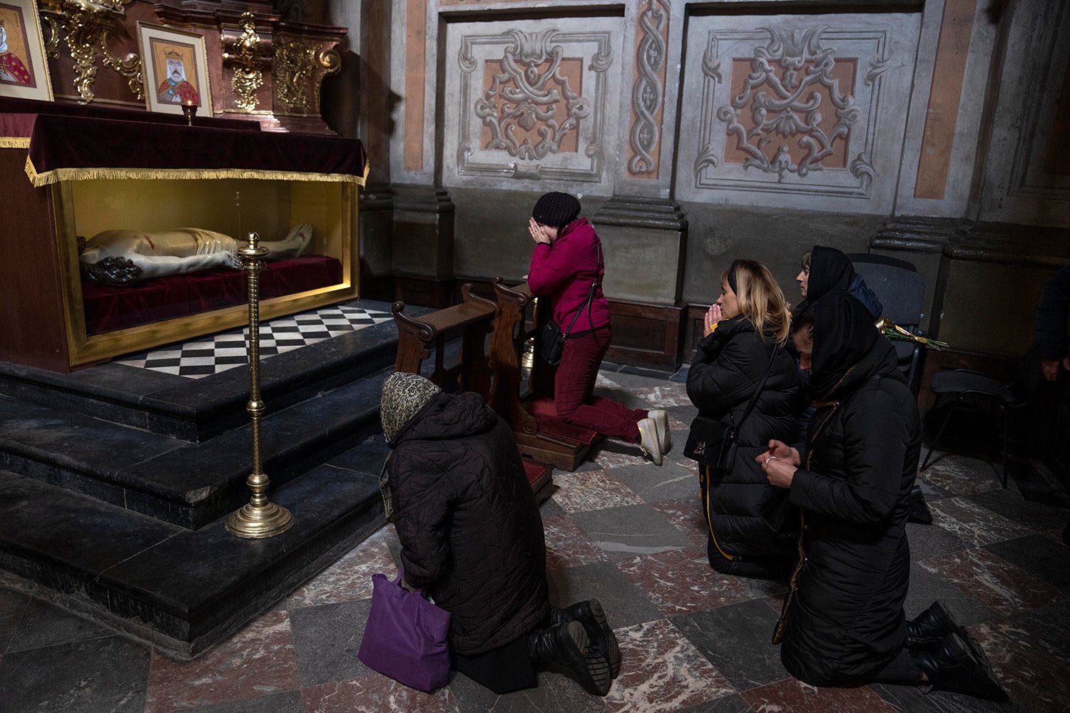  The wife, center, of 44-year-old soldier Tereshko Volodymyr, second right, prays and mourns his death before his funeral ceremony, after he died in action, at the Holy Apostles Peter and Paul Church in Lviv, western Ukraine, Monday, April 4, 2022. (