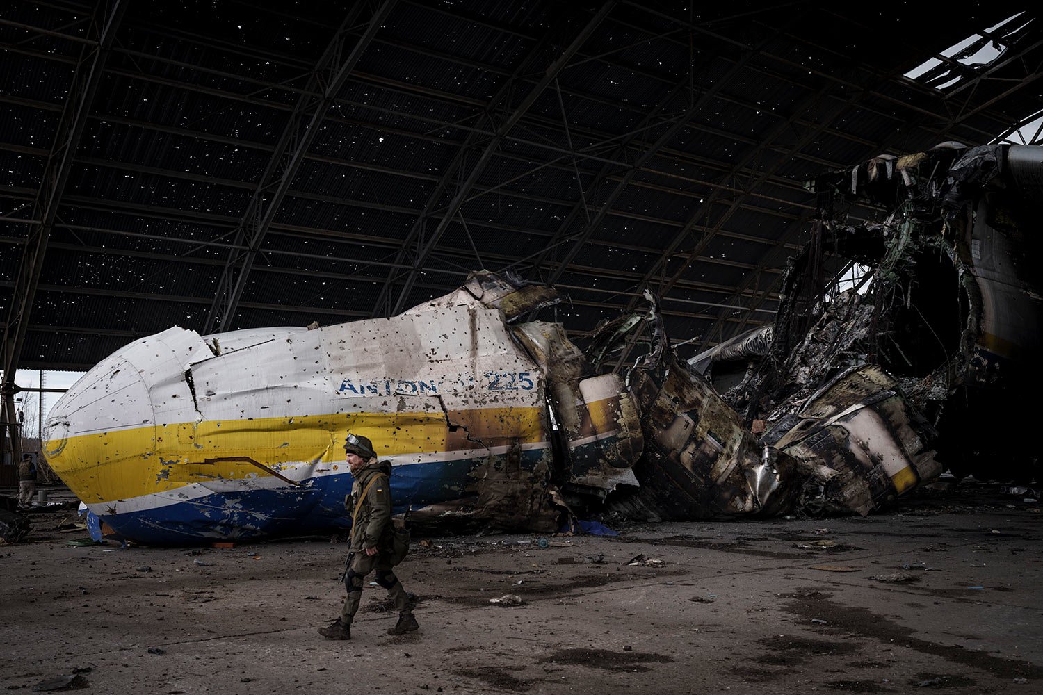  A Ukrainian serviceman walks past the Antonov An-225 aircraft destroyed during fighting between Russian and Ukrainian forces, at the Antonov airport in Hostomel, outskirts of Kyiv, Ukraine, Monday, April 4, 2022. (AP Photo/Felipe Dana) 