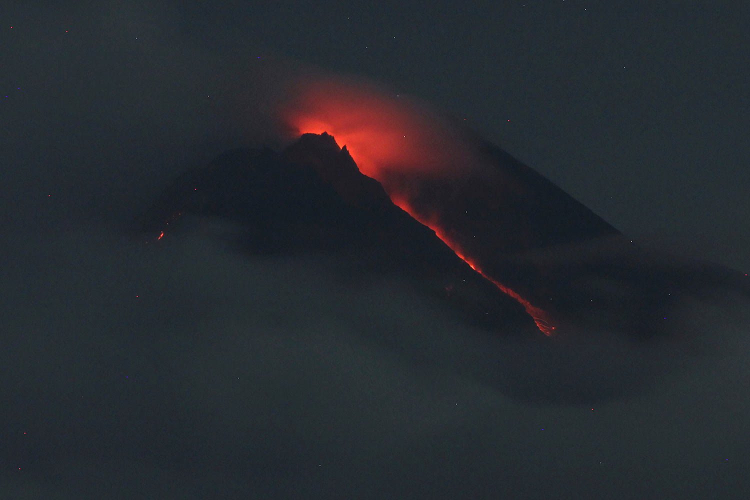  Lava flows down from the crater of Mount Merapi seen from Pakembinangun village in Sleman, Central Java, Thursday, March 10, 2022. (AP Photo/Ranto Kresek) 