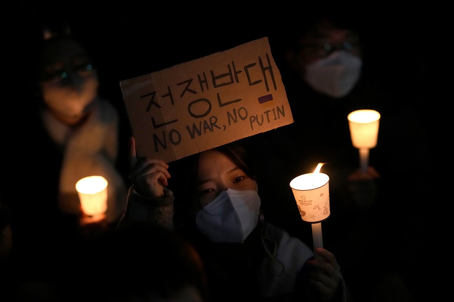  People hold candles during a candlelight vigil supporting Ukraine for peace and safety and demanding to stop the war near the Russia Embassy in Seoul, South Korea, Friday, March 4, 2022. (AP Photo/Lee Jin-man) 