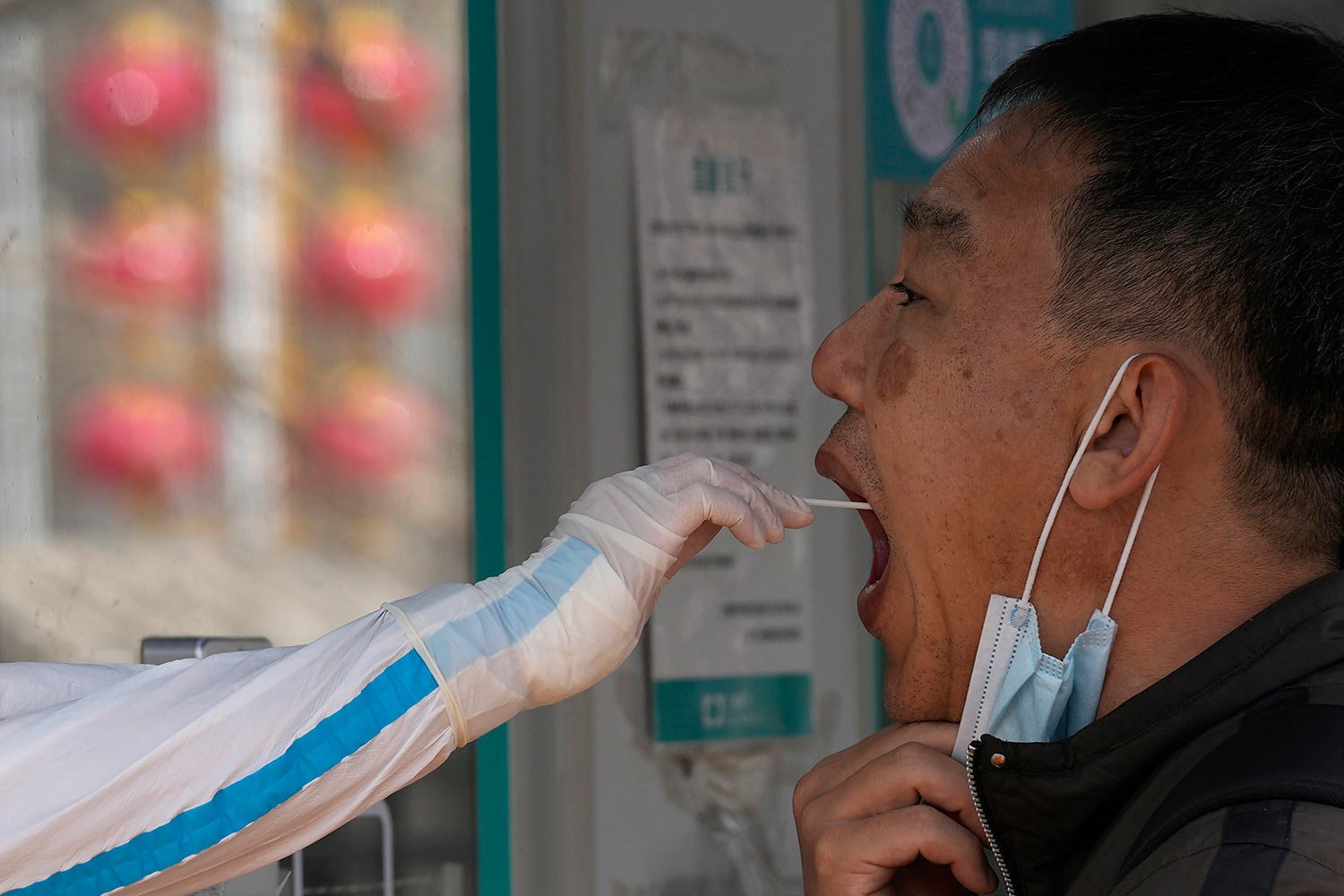  A worker takes a swab sample for a COVID-19 test at a mobile testing site on Tuesday, March 15, 2022, in Beijing.  (AP Photo/Ng Han Guan) 