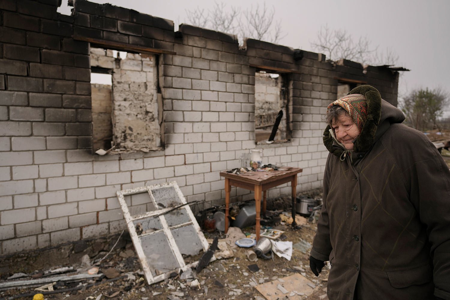  A woman walks by a house destroyed while her village was occupied by Russian troops in Andriivka, Ukraine, Tuesday, April 5, 2022. (AP Photo/Vadim Ghirda) 