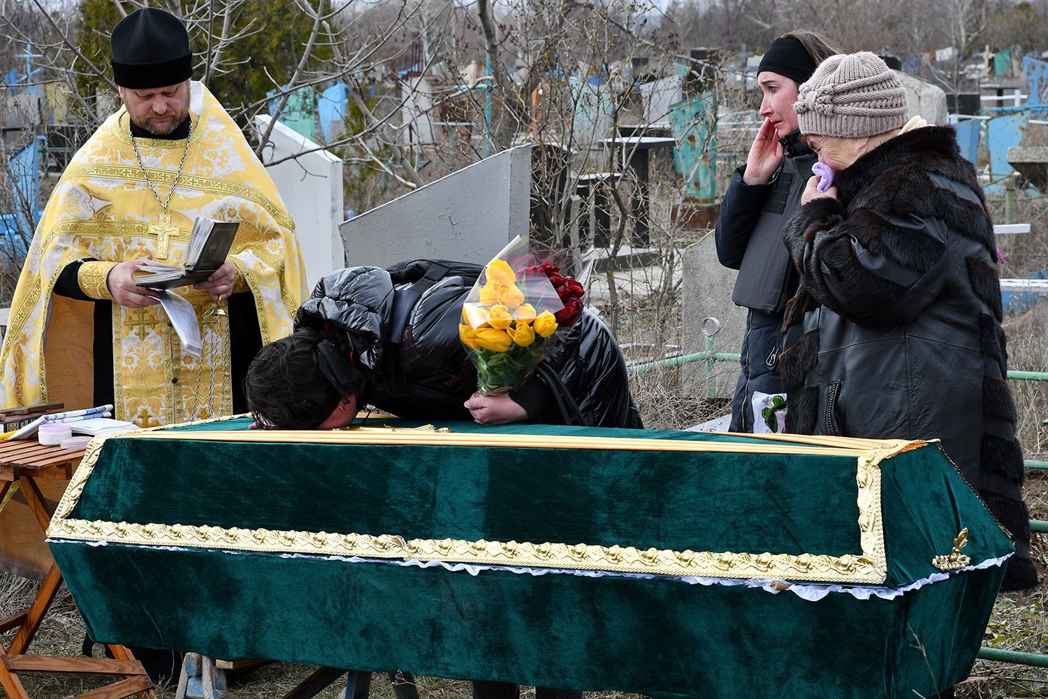 Relatives and friends stand near the coffin of Ukrainian serviceman Anatoly German during a funeral ceremony in Kramatorsk, Ukraine, Tuesday, April 5, 2022. Anatoly German was killed during fightings between Russian and Ukrainian forces near the cit
