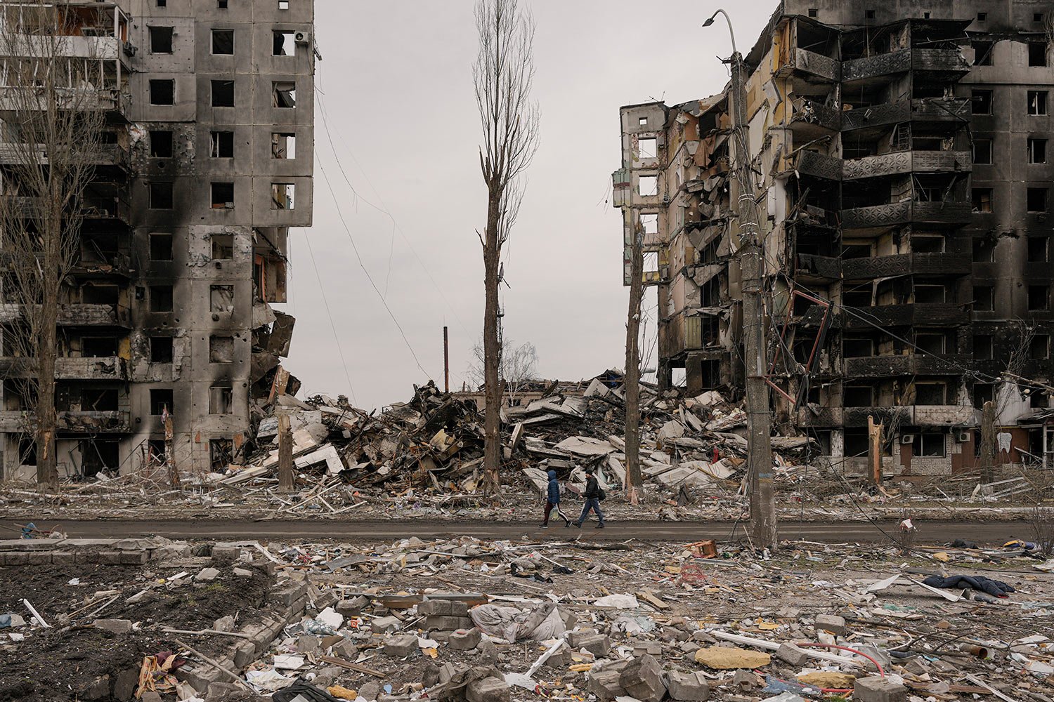  People walk by an apartment building destroyed during fighting between Ukrainian and Russian forces in Borodyanka, Ukraine, Tuesday, April 5, 2022. (AP Photo/Vadim Ghirda) 